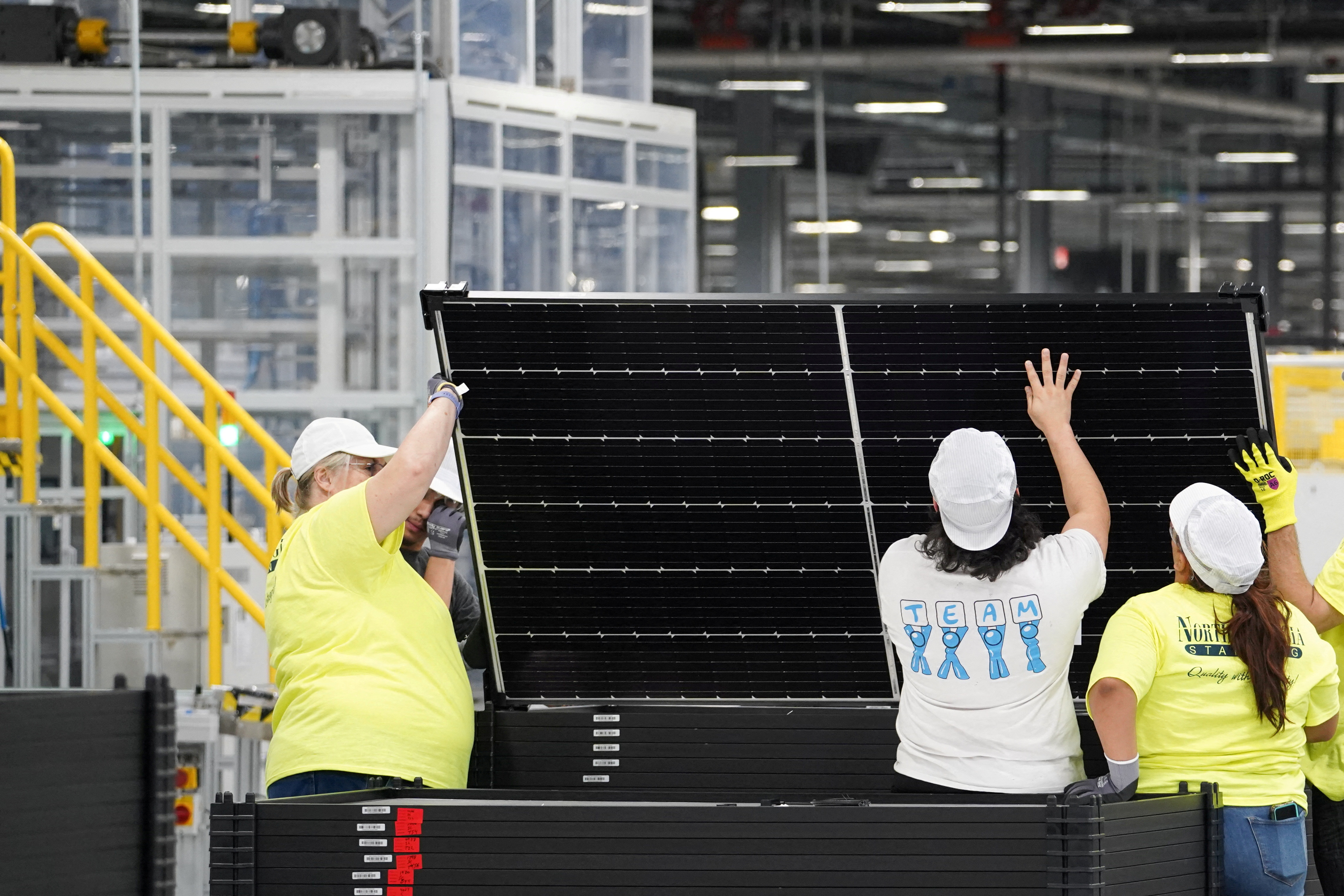 Employees work on solar panels at the QCells solar manufacturing factory in Dalton