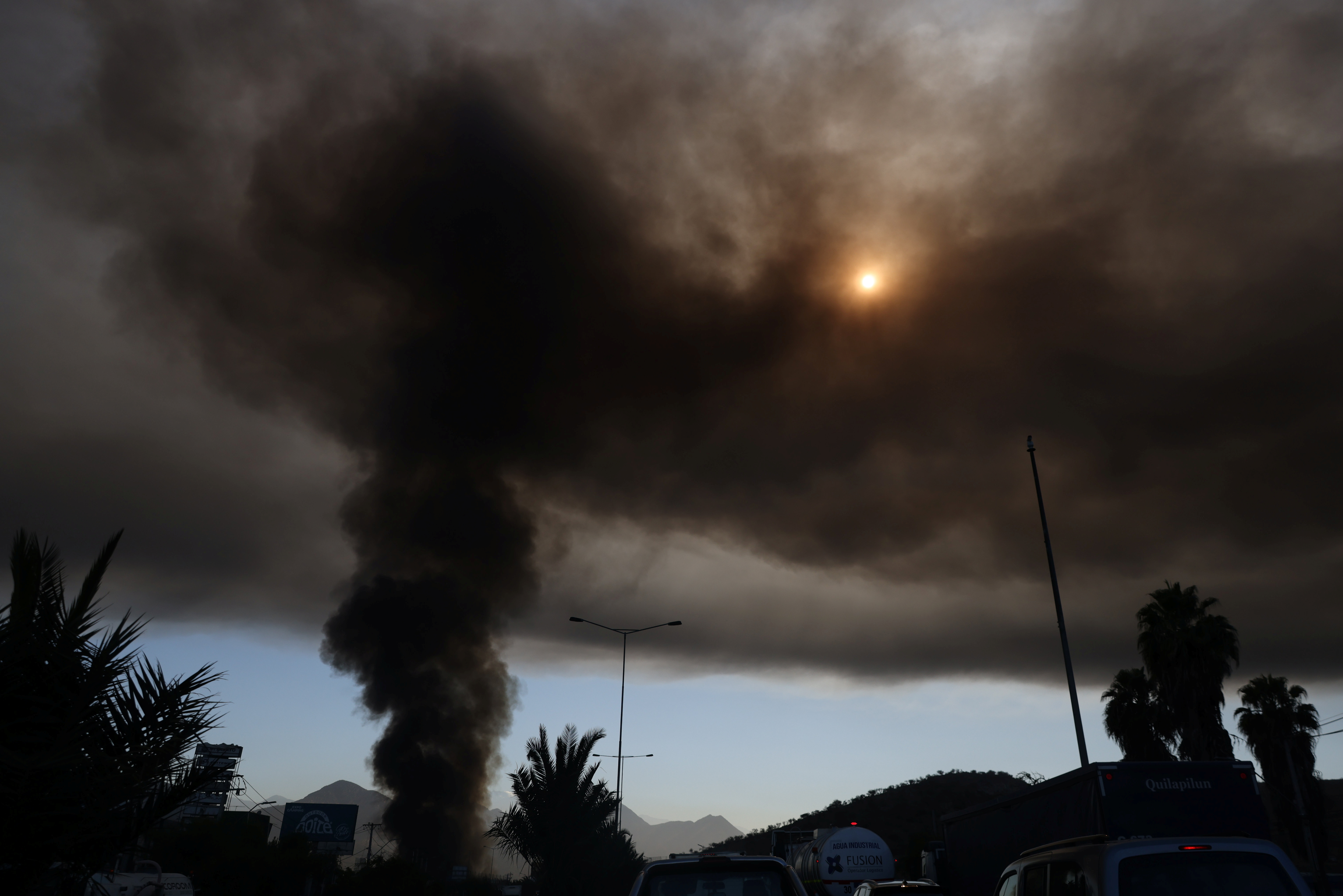 A smoke column rises from a fire in a factory in Santiago, Chile, November 29, 2021. REUTERS/Ivan Alvarado