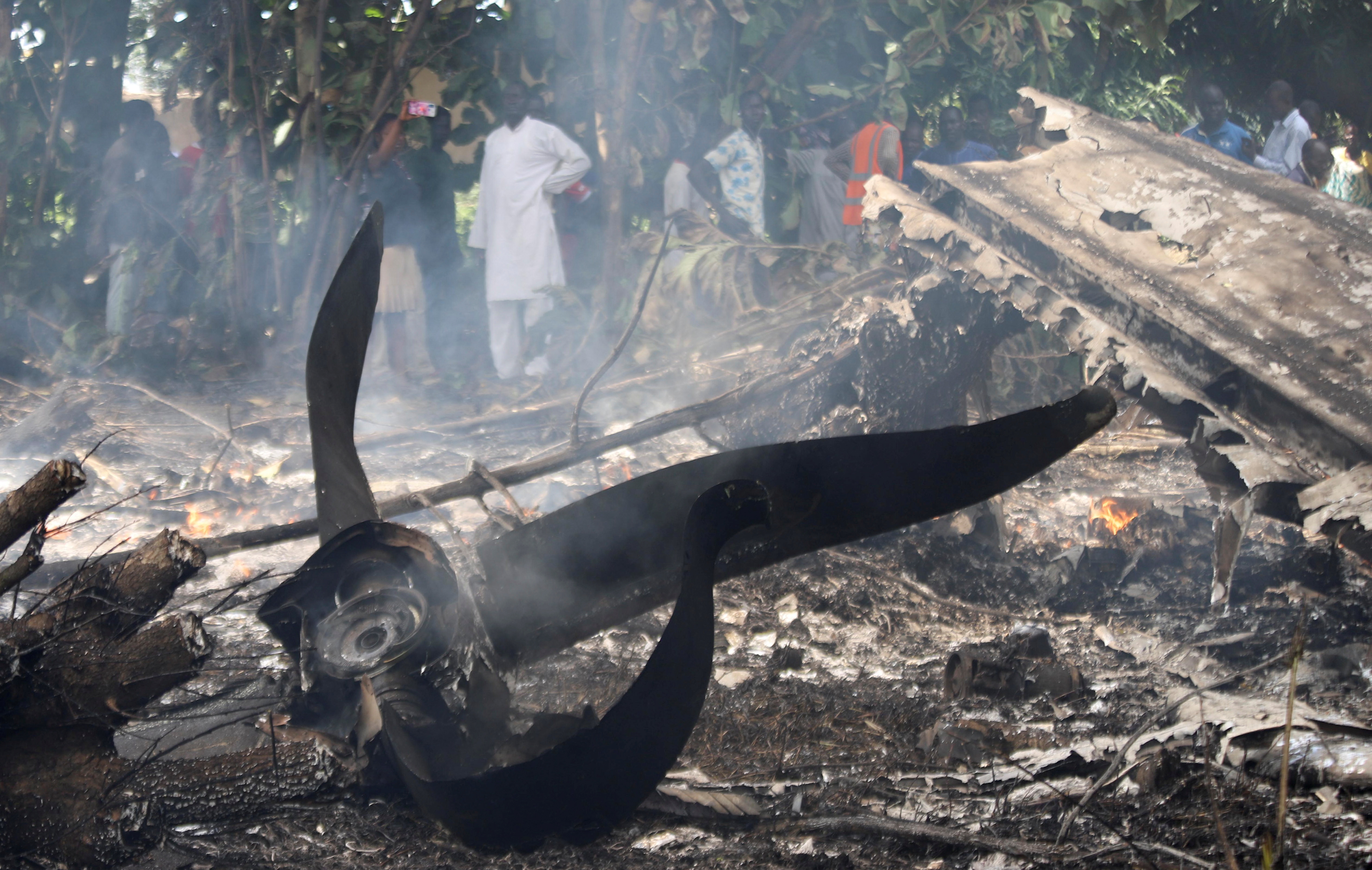 Civilians stand near the burning wreckage of an Antonov-26 plane operated by Optimum Aviation, that crashed shortly after take-off from Juba Airport in Juba