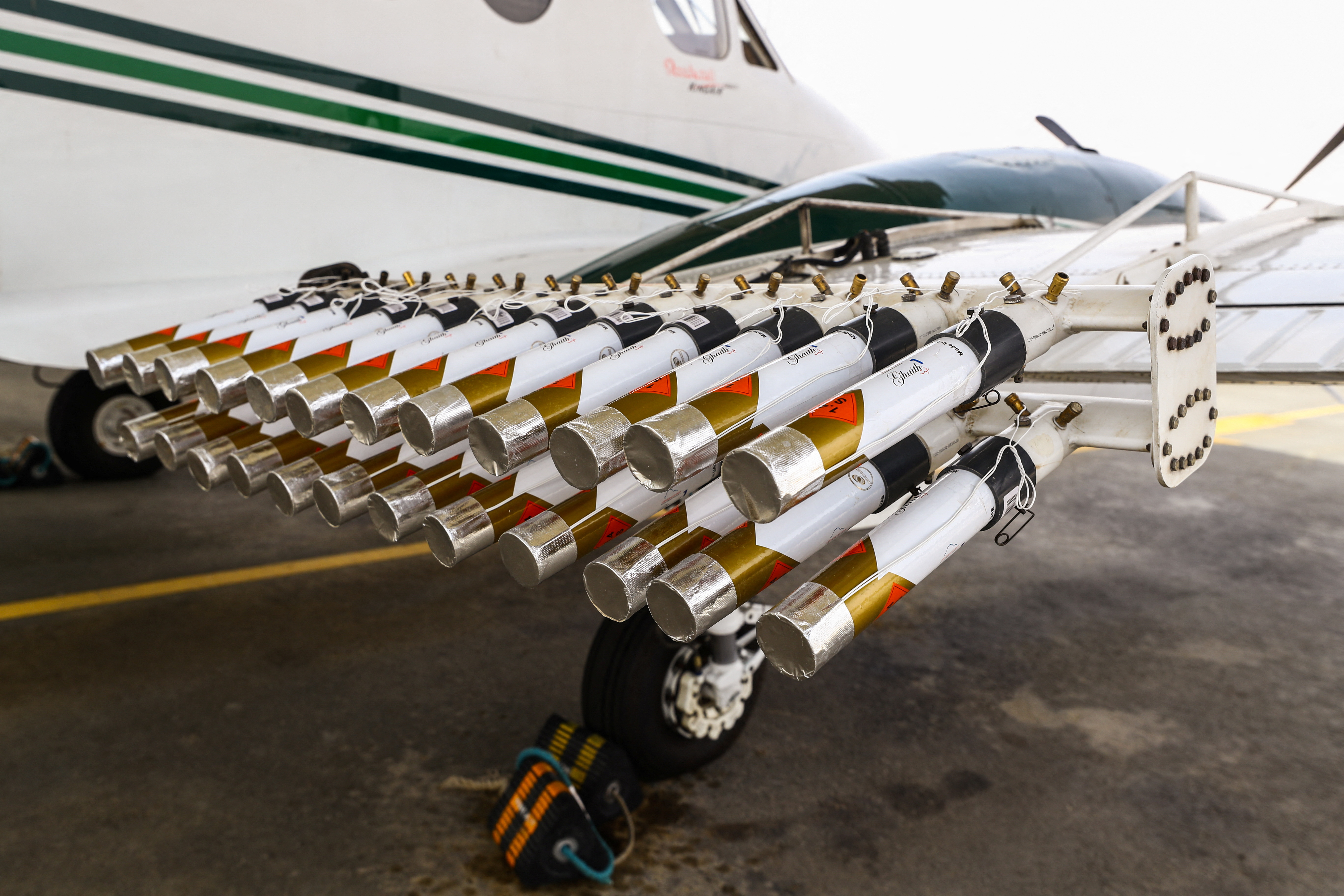 Hygroscopic flares are attached to an aircraft ahead of a cloud seeding flight in United Arab Emirates