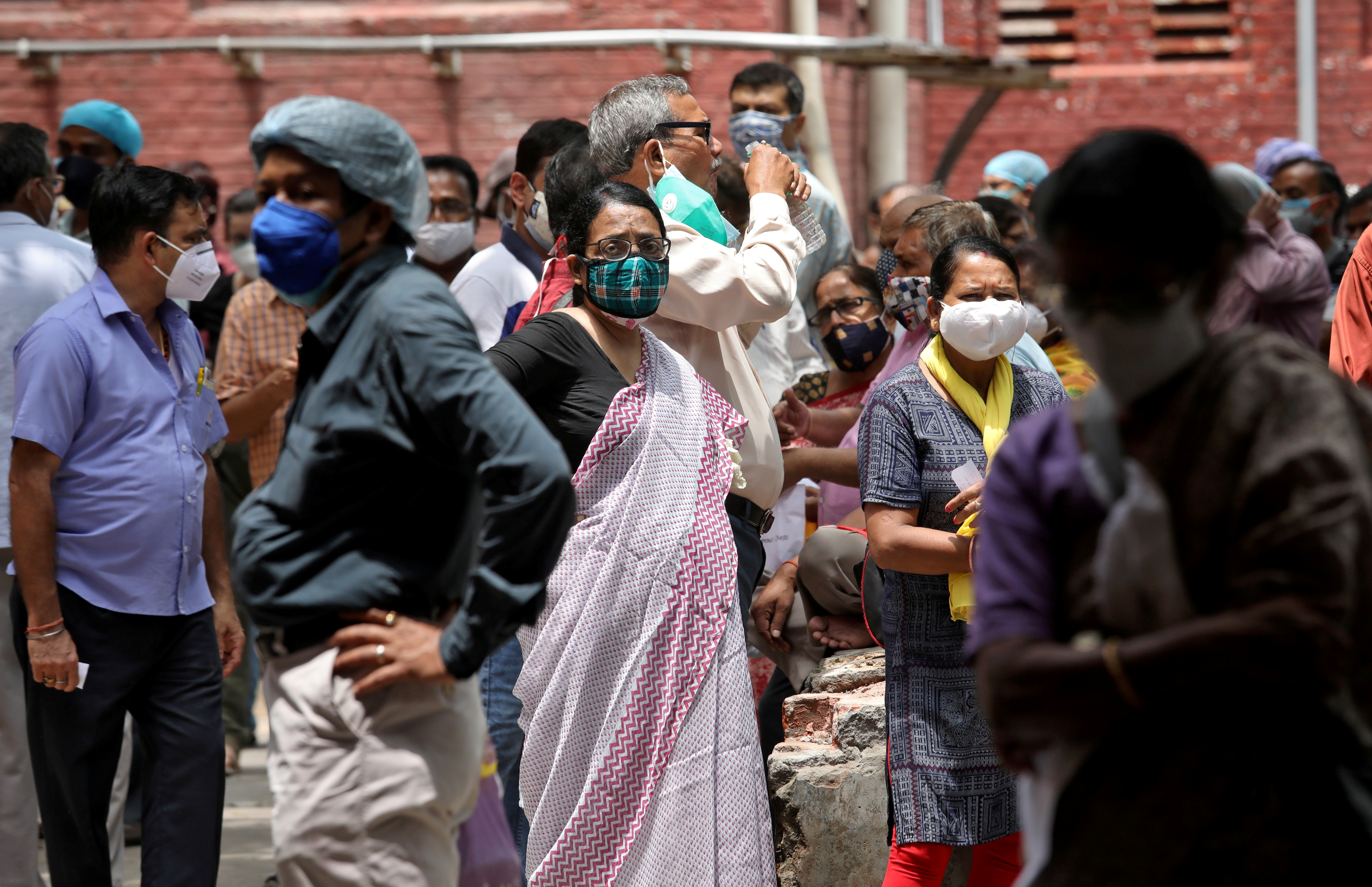 People wearing protective face masks wait to receive their second dose of COVISHIELD, a coronavirus disease (COVID-19) vaccine manufactured by Serum Institute of India, outside a vaccination centre in Kolkata, India, May 12, 2021. REUTERS/Rupak De Chowdhuri