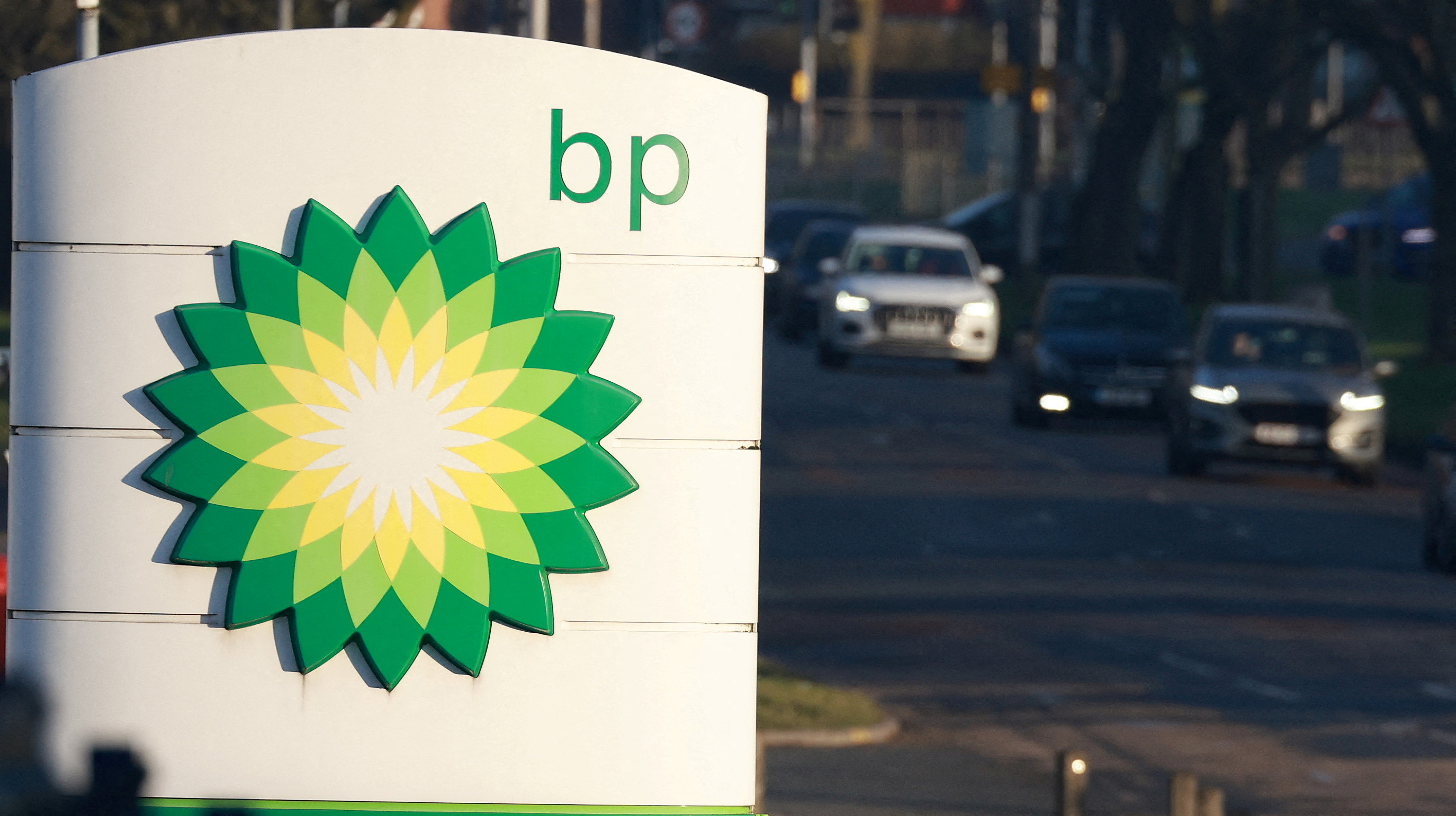 Vehicles drive past a BP (British Petroleum) petrol station in Liverpool
