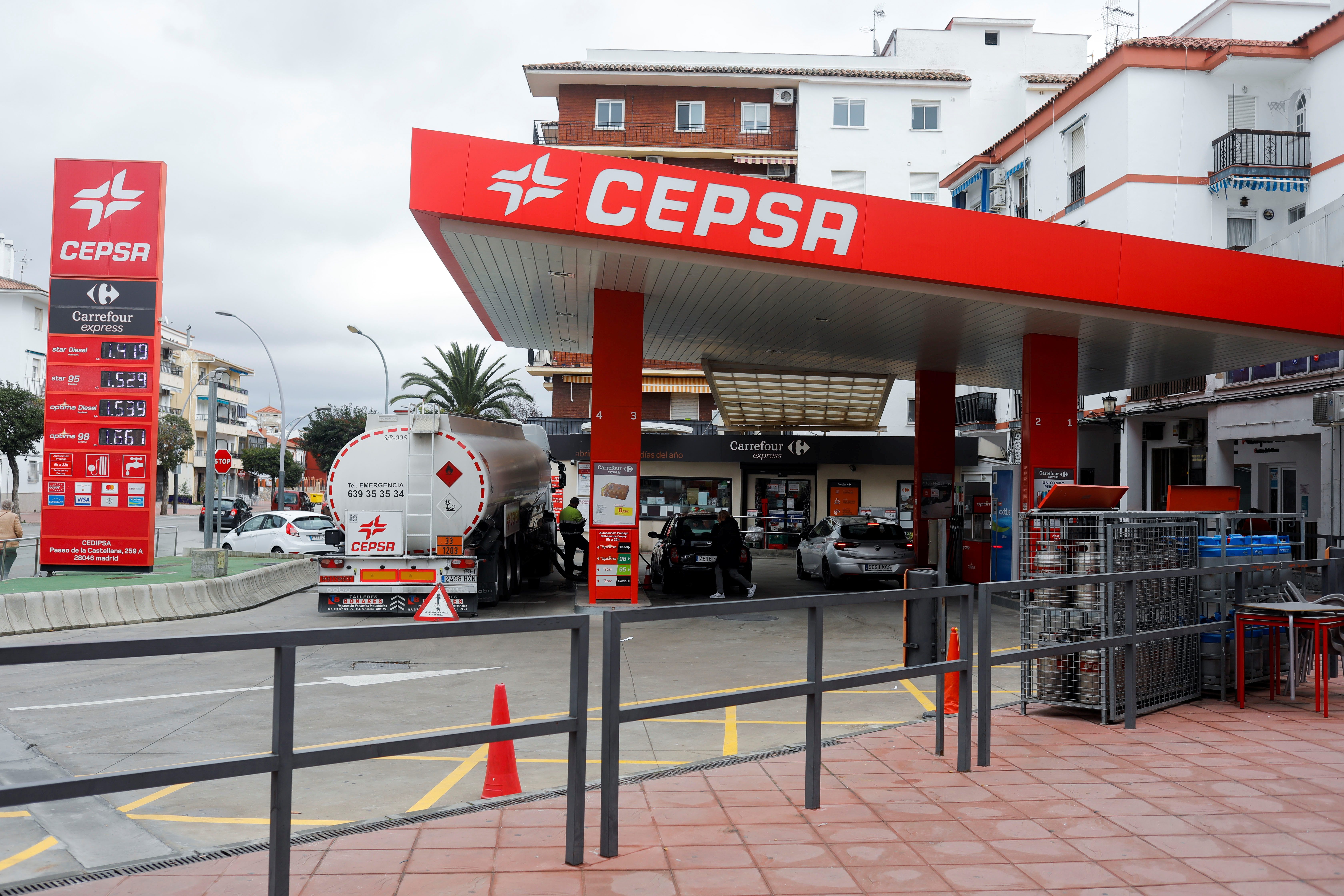 A worker refills fuel at a Cepsa petrol station in Ronda