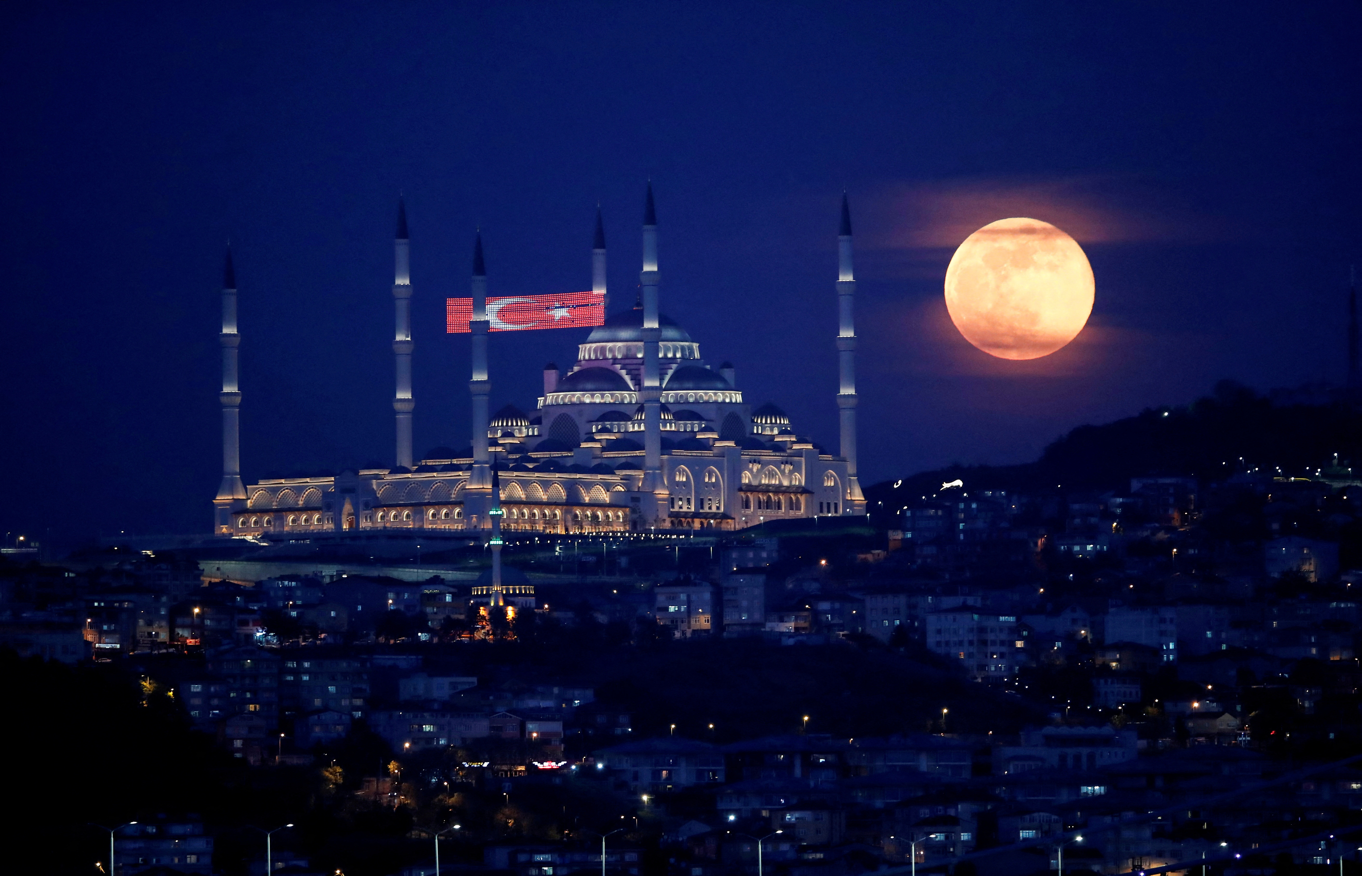 La luna llena, también conocida como Superluna o Luna de Flores, se eleva sobre la Mezquita Camlica durante la propagación de la enfermedad del coronavirus (COVID-19), en Estambul