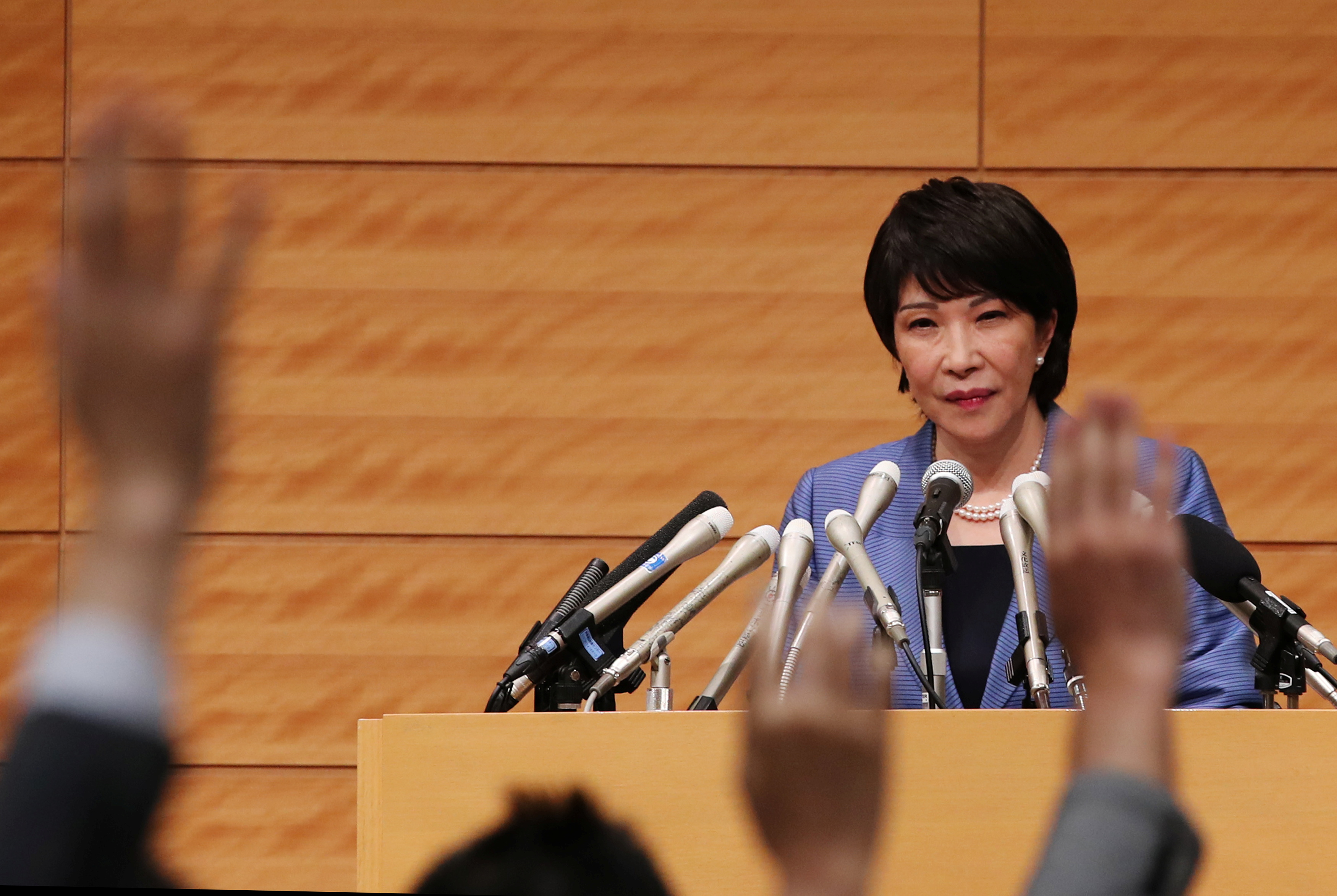 Japanese lawmaker Sanae Takaichi looks at members of the media at a news conference in Tokyo