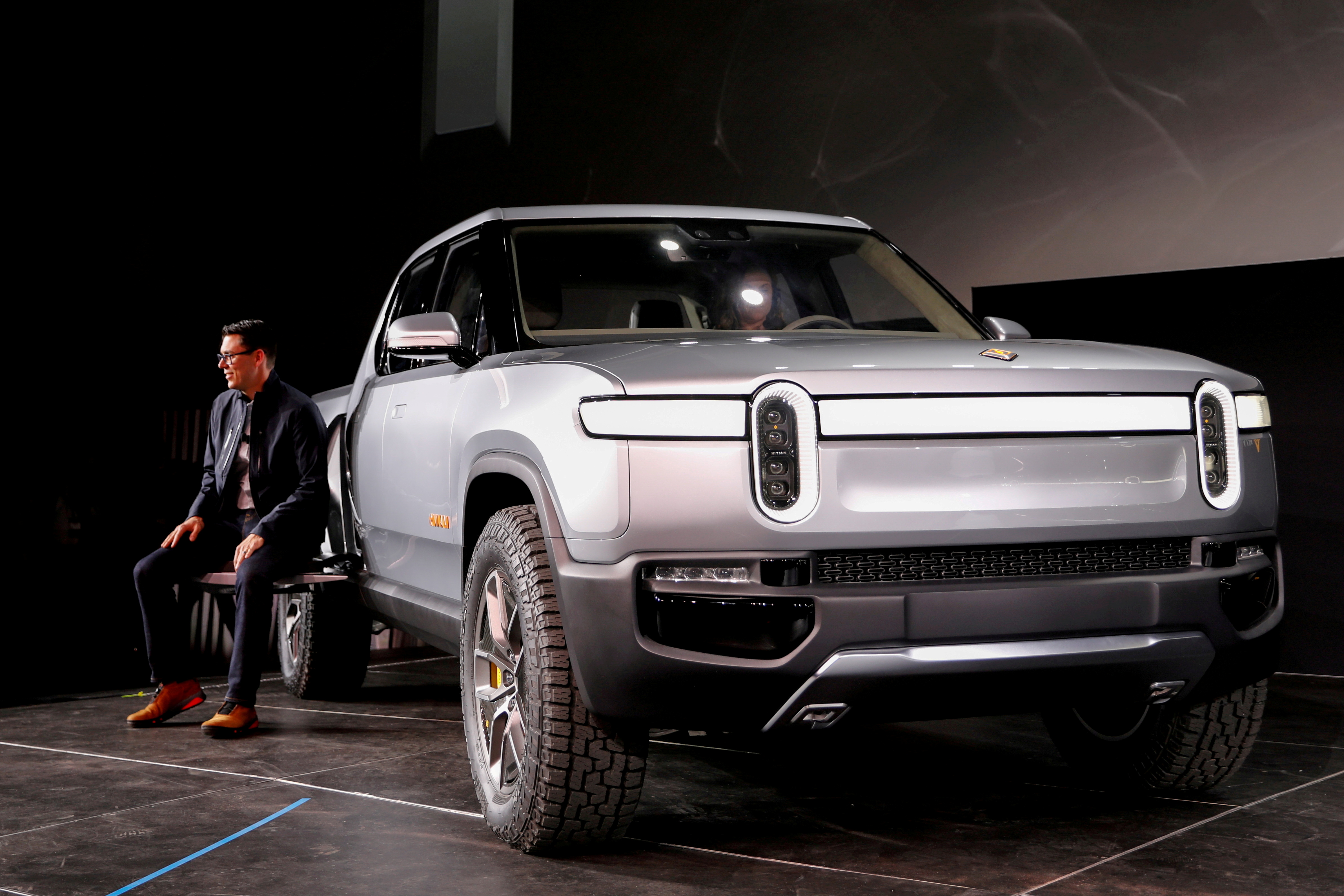 Rivian's CEO, Scaringe, with the R1T all-electric pickup truck at LA Auto Show in Los Angeles