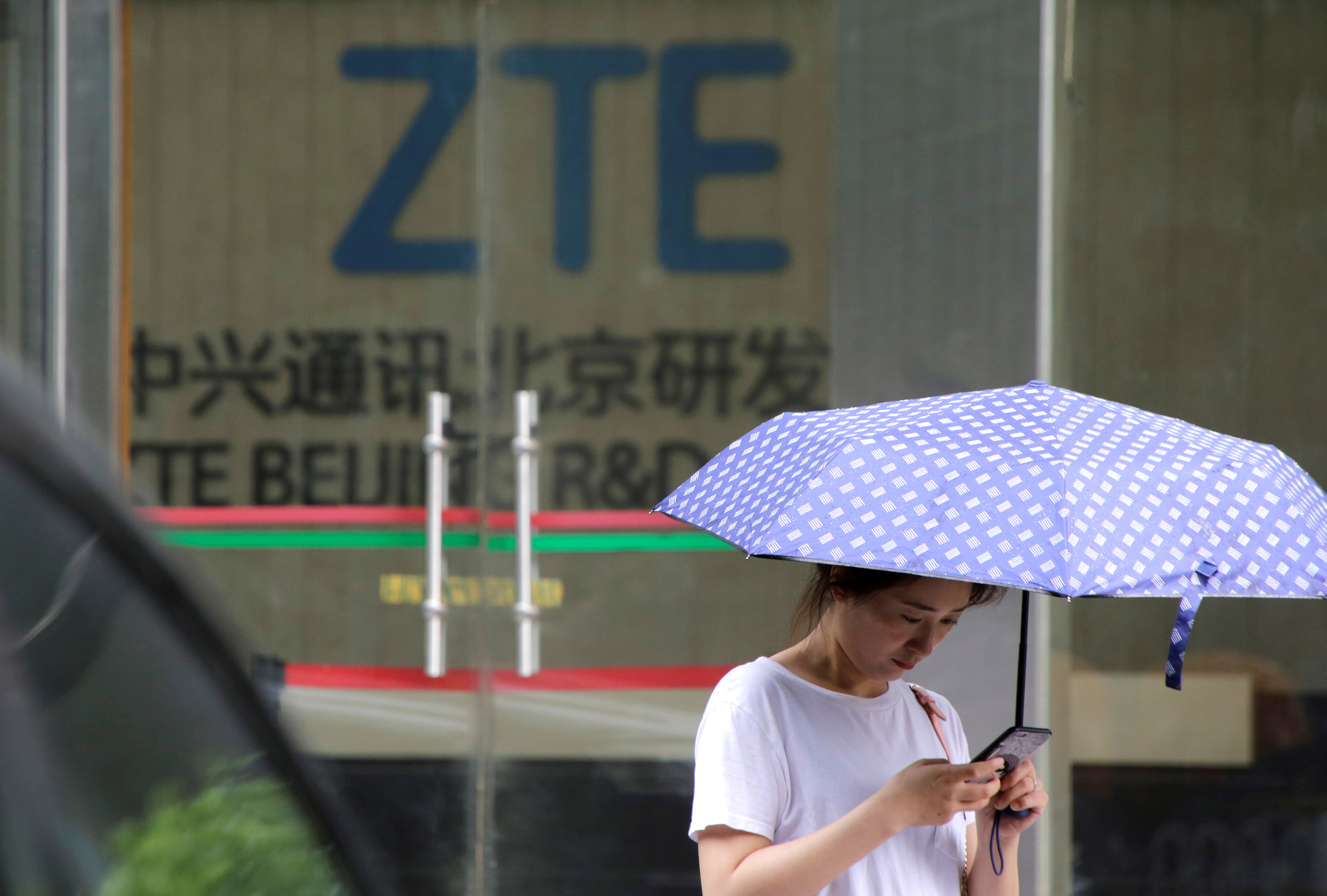 A woman stands outside a building of ZTE Beijing research and development center in Beijing