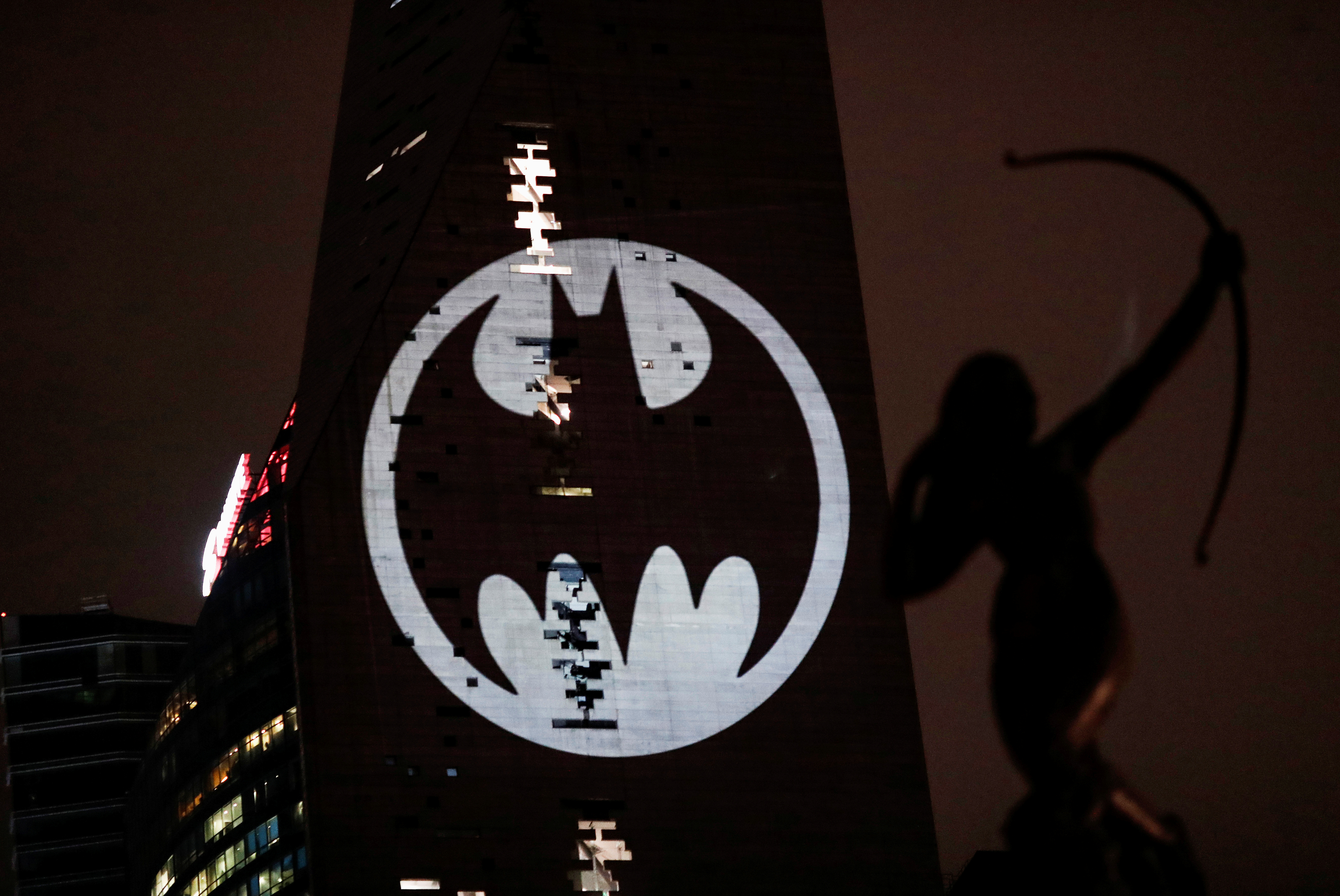 A Bat-Signal is projected onto a building at night as Batman fans celebrate the 80th anniversary of the first appearance of the DC Comics superhero, in Mexico City