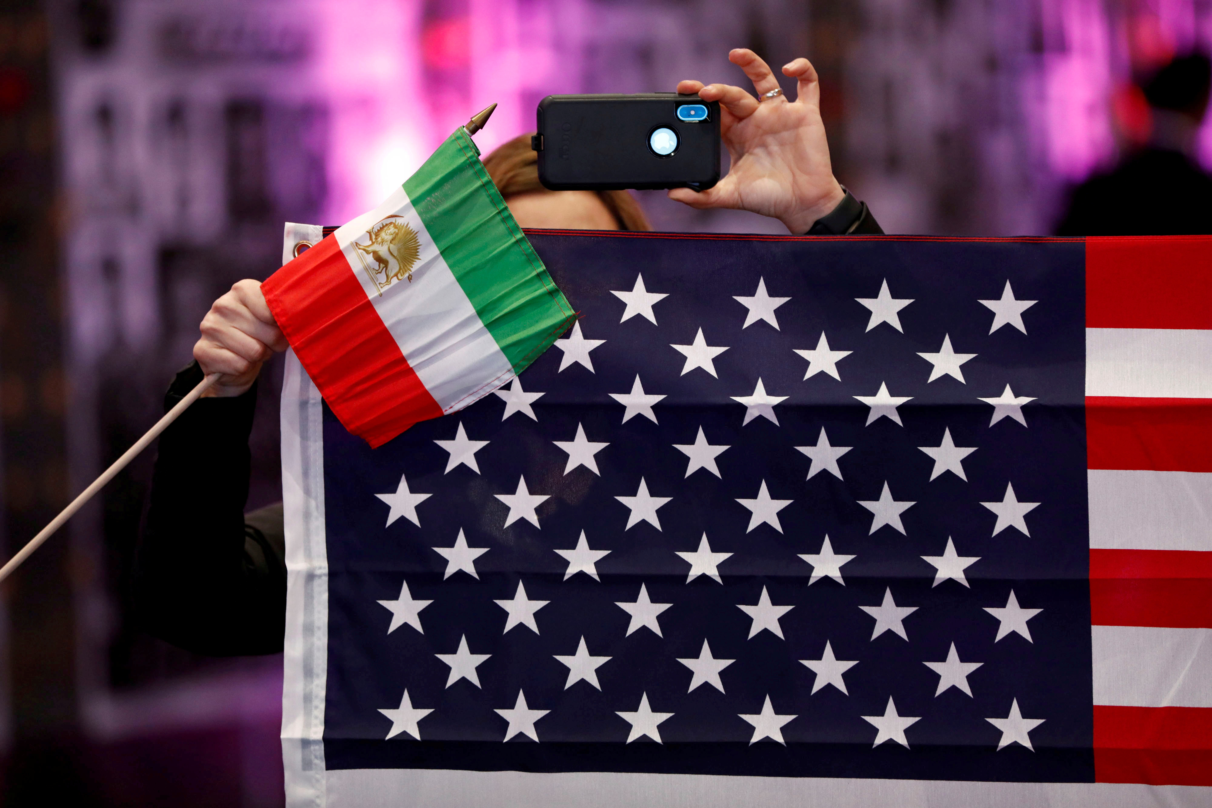 Attendees hold flags from Iran and the United States as Iranian Americans from across California converge in Los Angeles to participate in the California Convention for a Free Iran and to express support for nationwide protests in Iran