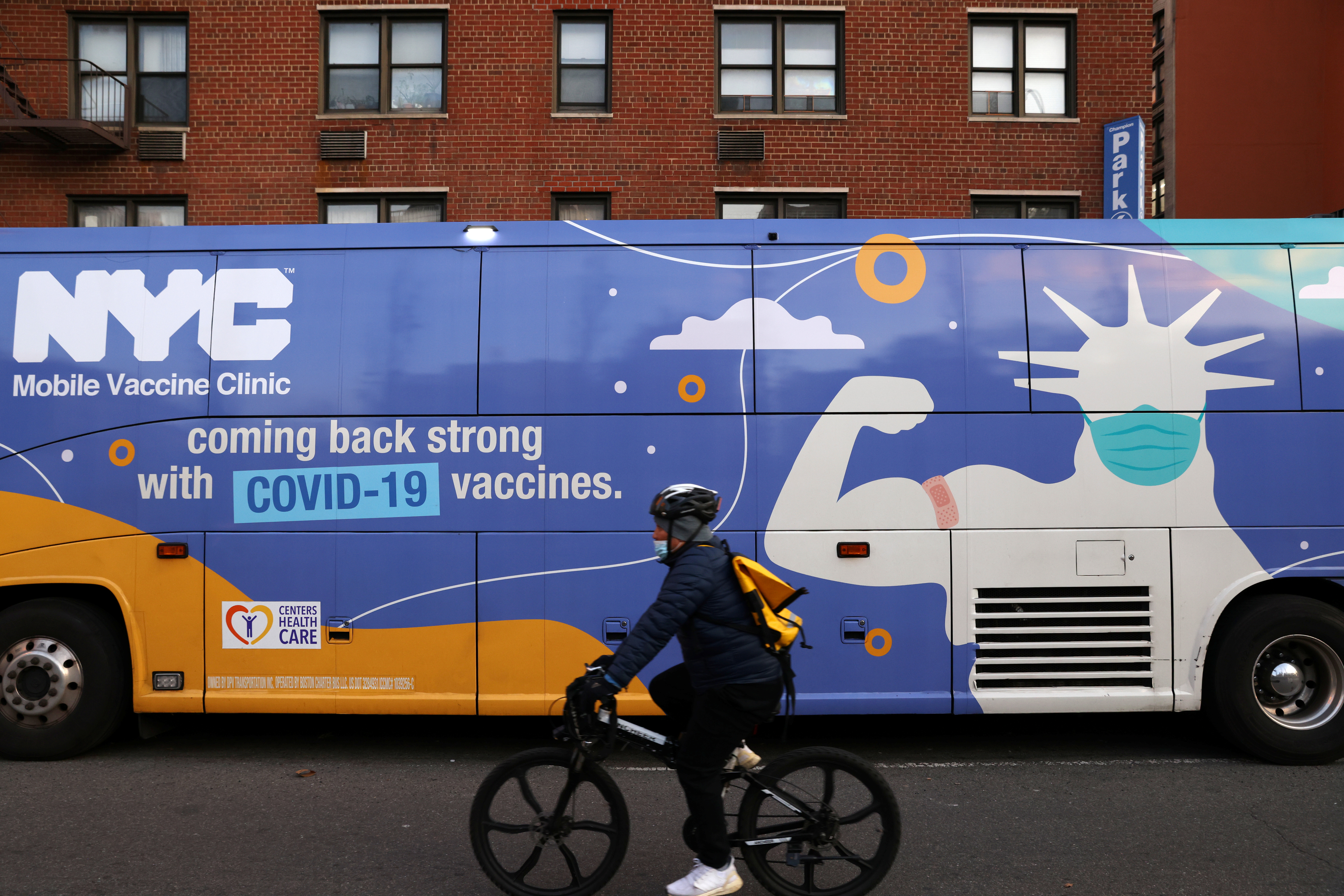 A person rides past a mobile coronavirus disease (COVID-19) vaccine clinic during the spread of the Omicron coronavirus variant in Manhattan