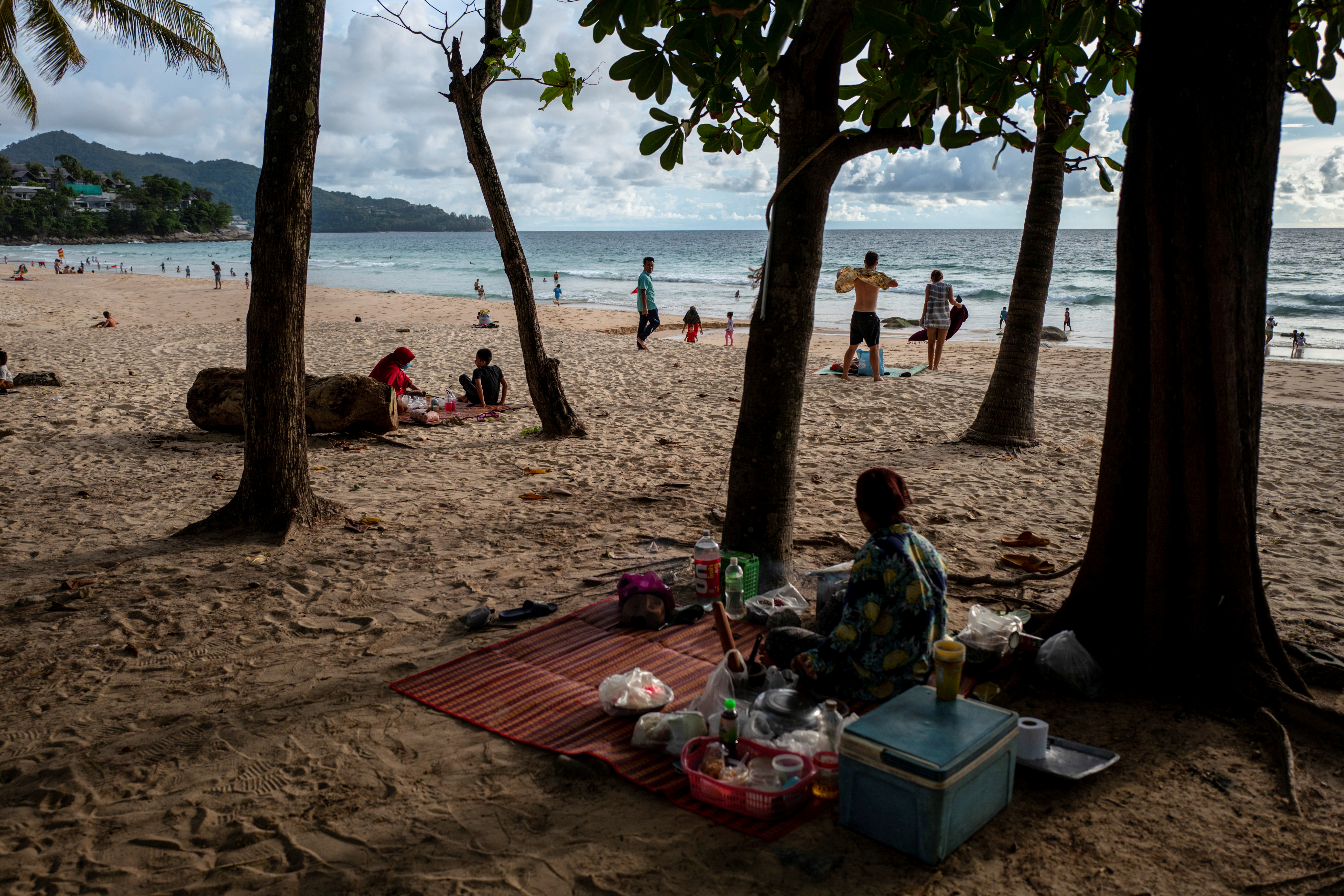 People enjoy at a beach as Phuket opens for foreigners, who are fully vaccinated against the coronavirus disease (COVID-19), to visit the resort island without quarantine, in Phuket, Thailand, September 19, 2021. REUTERS/Athit Perawongmetha/File Photo