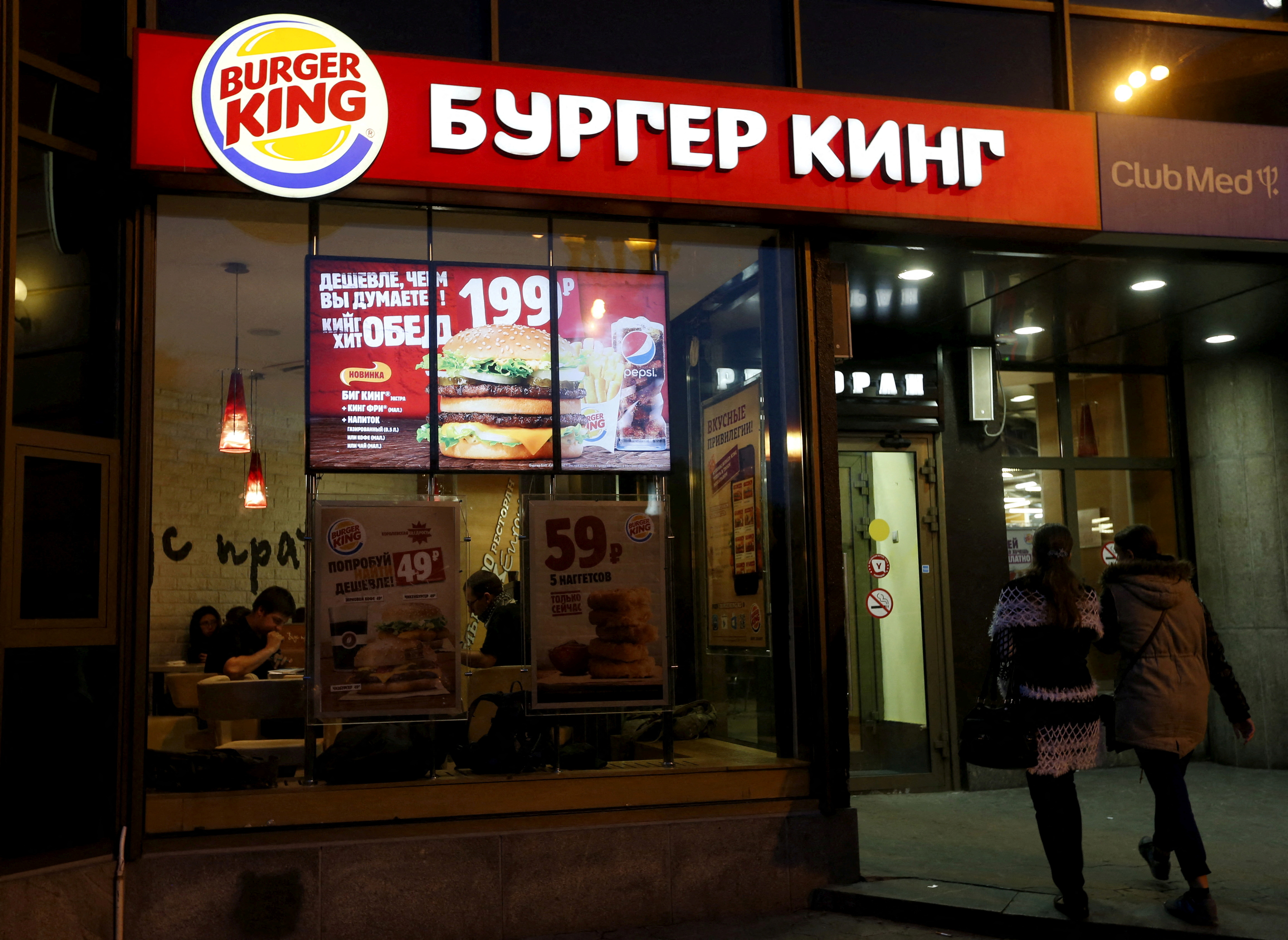 FILE PHOTO: Women walk outside a Burger King restaurant in Moscow