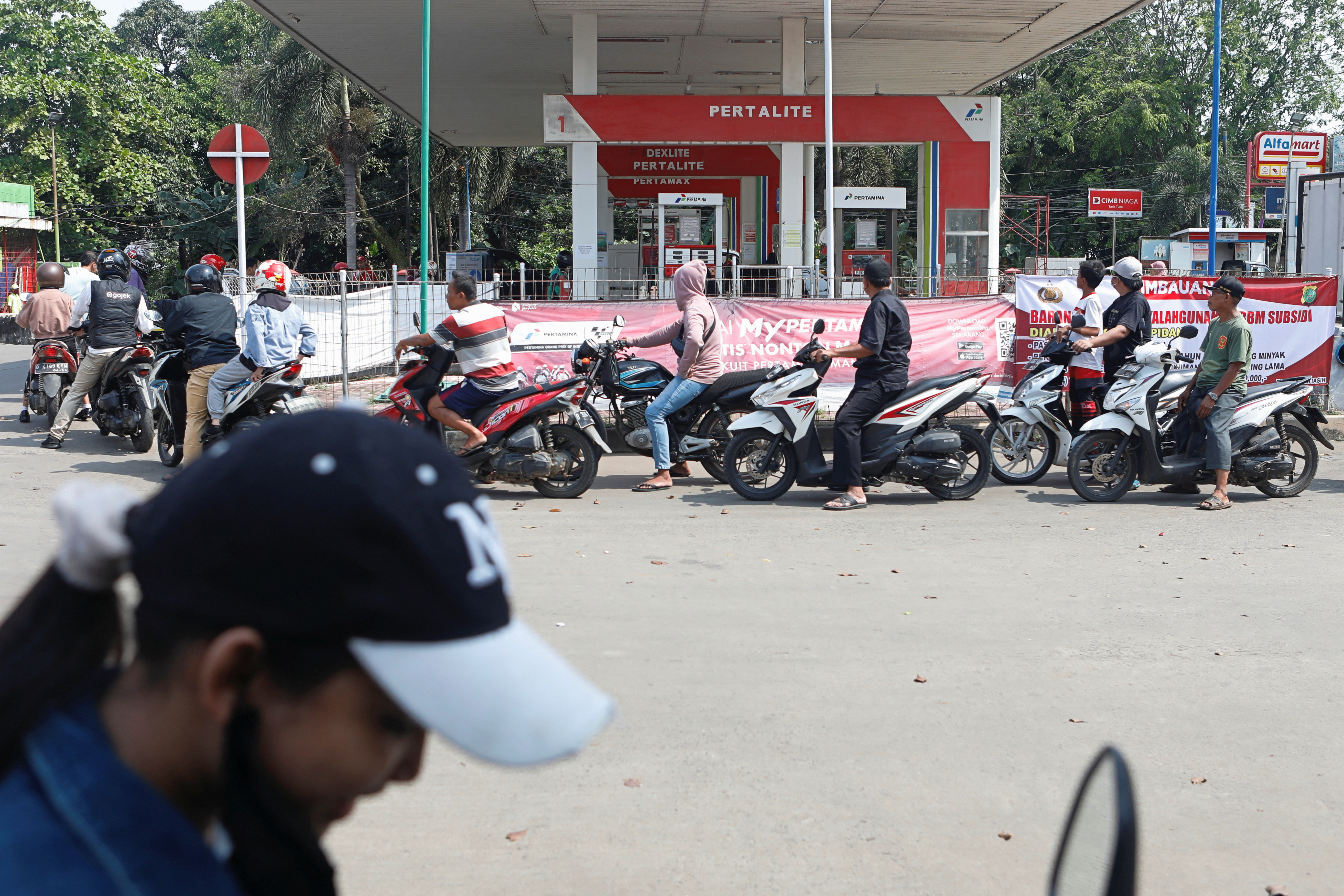 Motorcycle drivers wait in line to buy subsidised fuel at a petrol station of the state-owned company Pertamina after the announcement of a fuel price hike, in Bekasi
