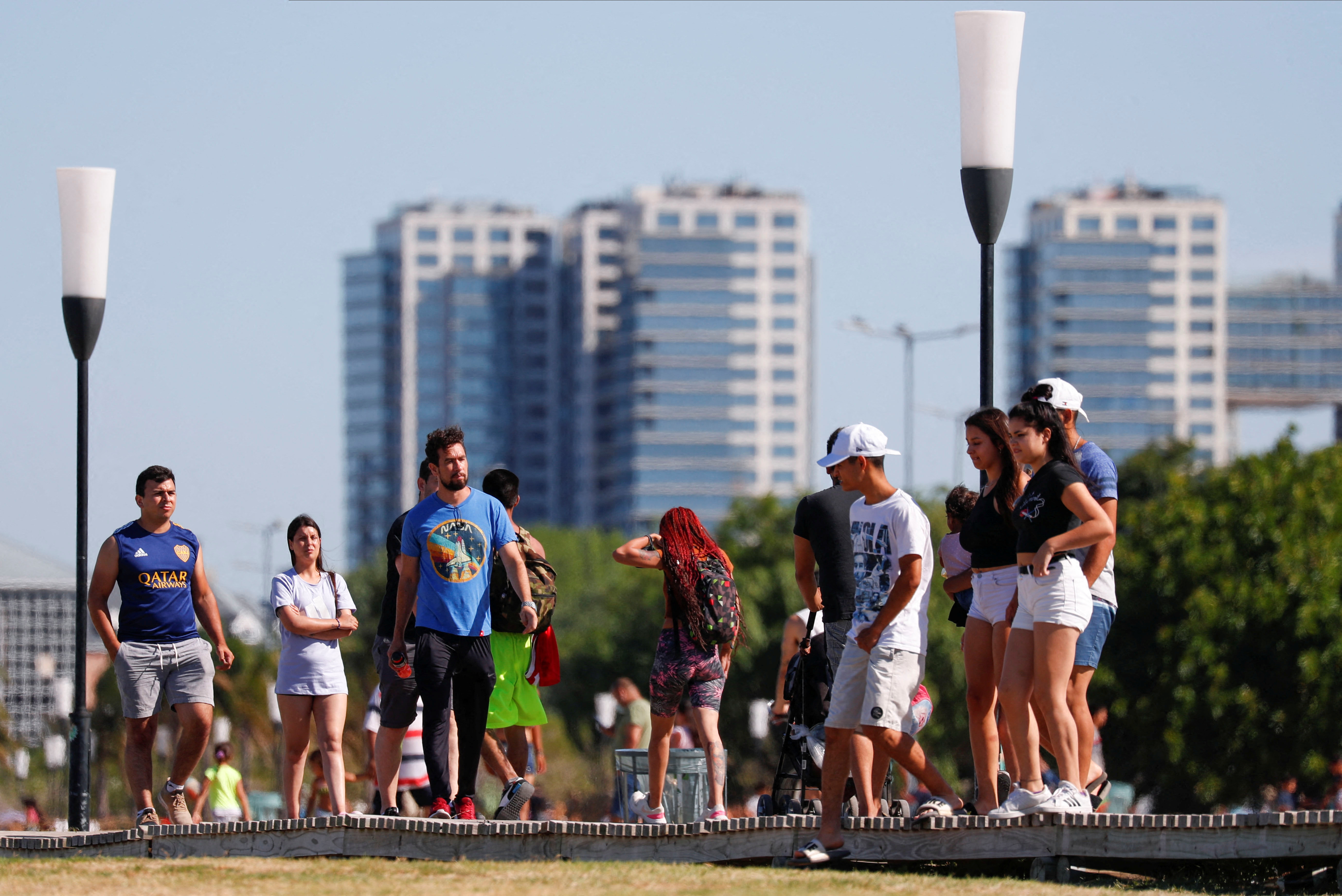 People enjoy the day by the shore of the Rio de la Plata river during a heat wave amid a spike of the coronavirus disease (COVID-19) cases, in Buenos Aires, Argentina January 9, 2022. REUTERS/Agustin Marcarian