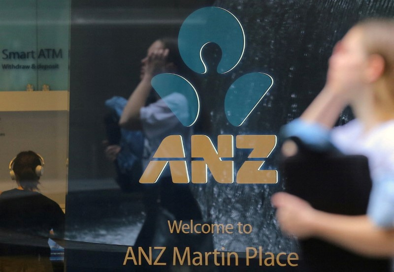 A pedestrian is reflected in the window of a branch of the Australia and New Zealand Banking Group (ANZ) in central Sydney