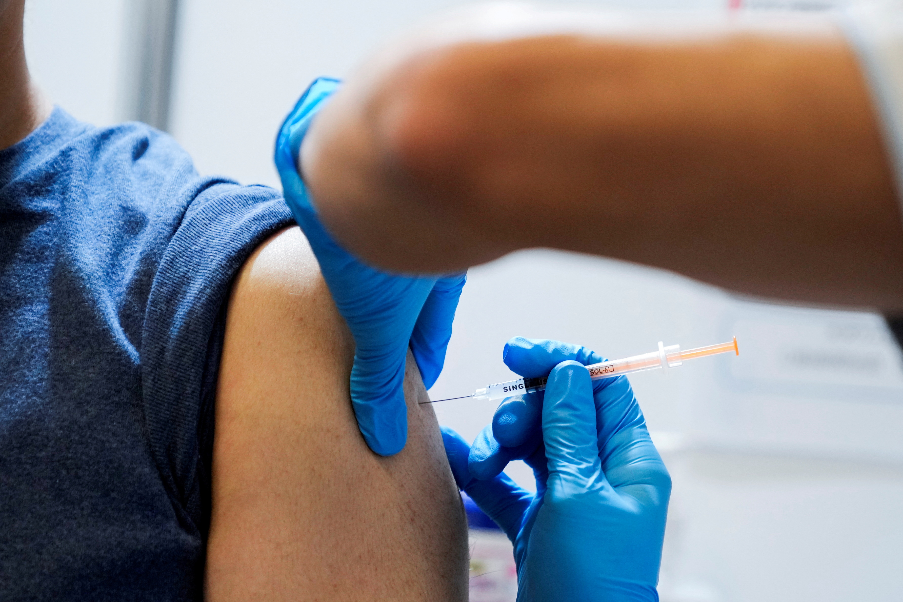A local resident receives a booster shot of the Moderna coronavirus disease (COVID-19) vaccine at a mass vaccination center operated by Japanese Self-Defense Force, in Tokyo