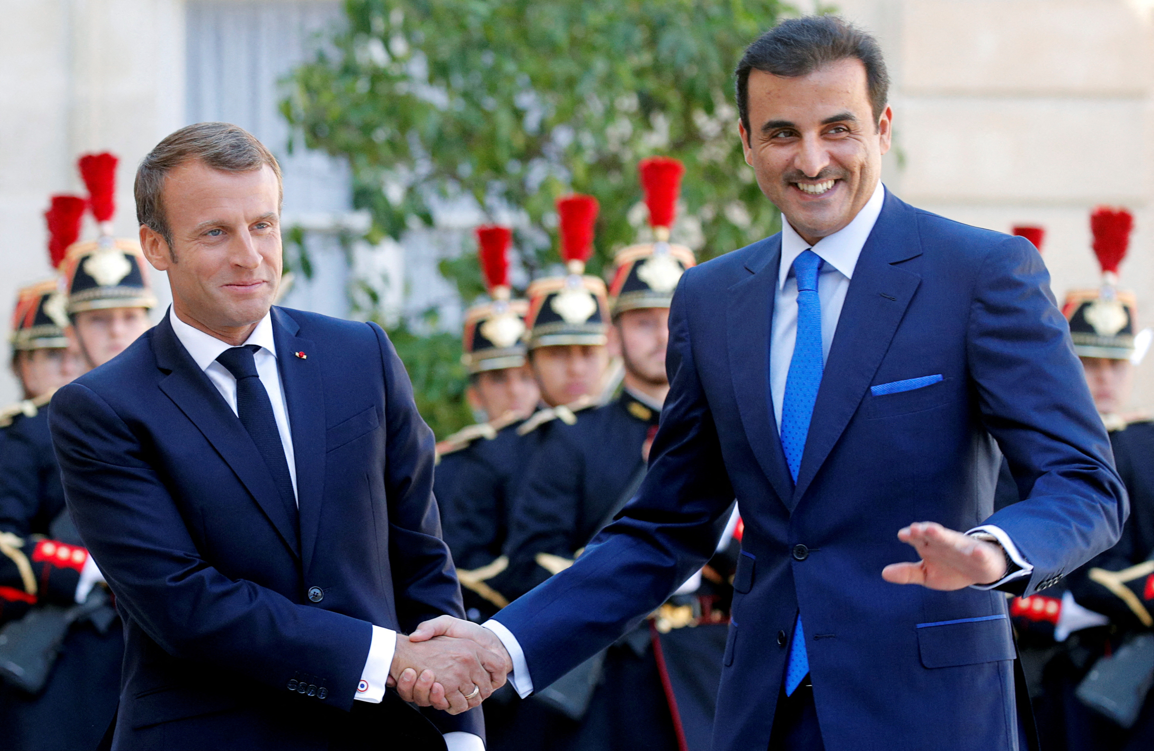 French President Emmanuel Macron welcomes Qatar's Emir Sheikh Tamim bin Hamad al-Thani at the Elysee Palace in Paris