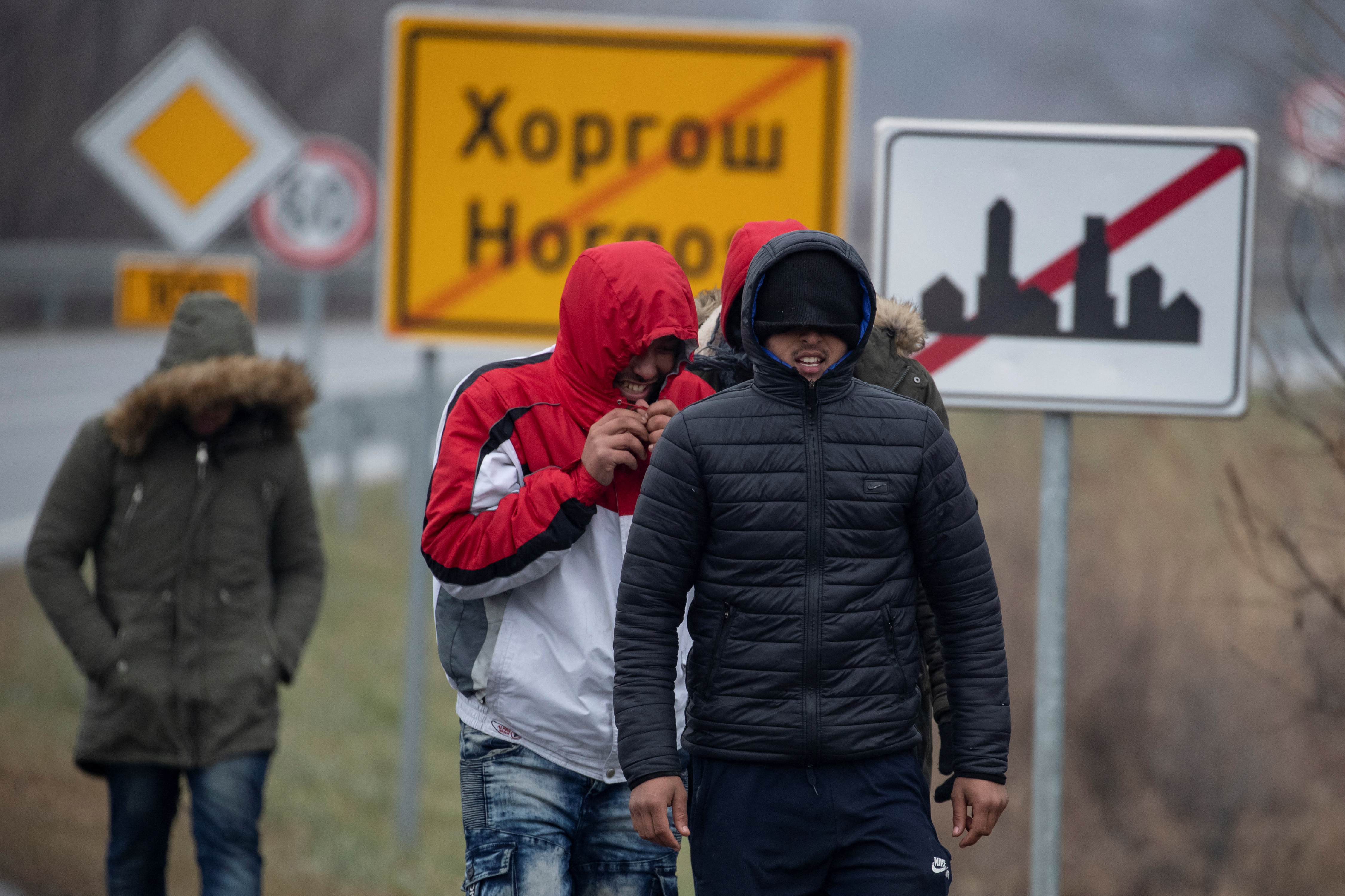 Migrants walk along a road near the Hungary-Serbia border in Horgos