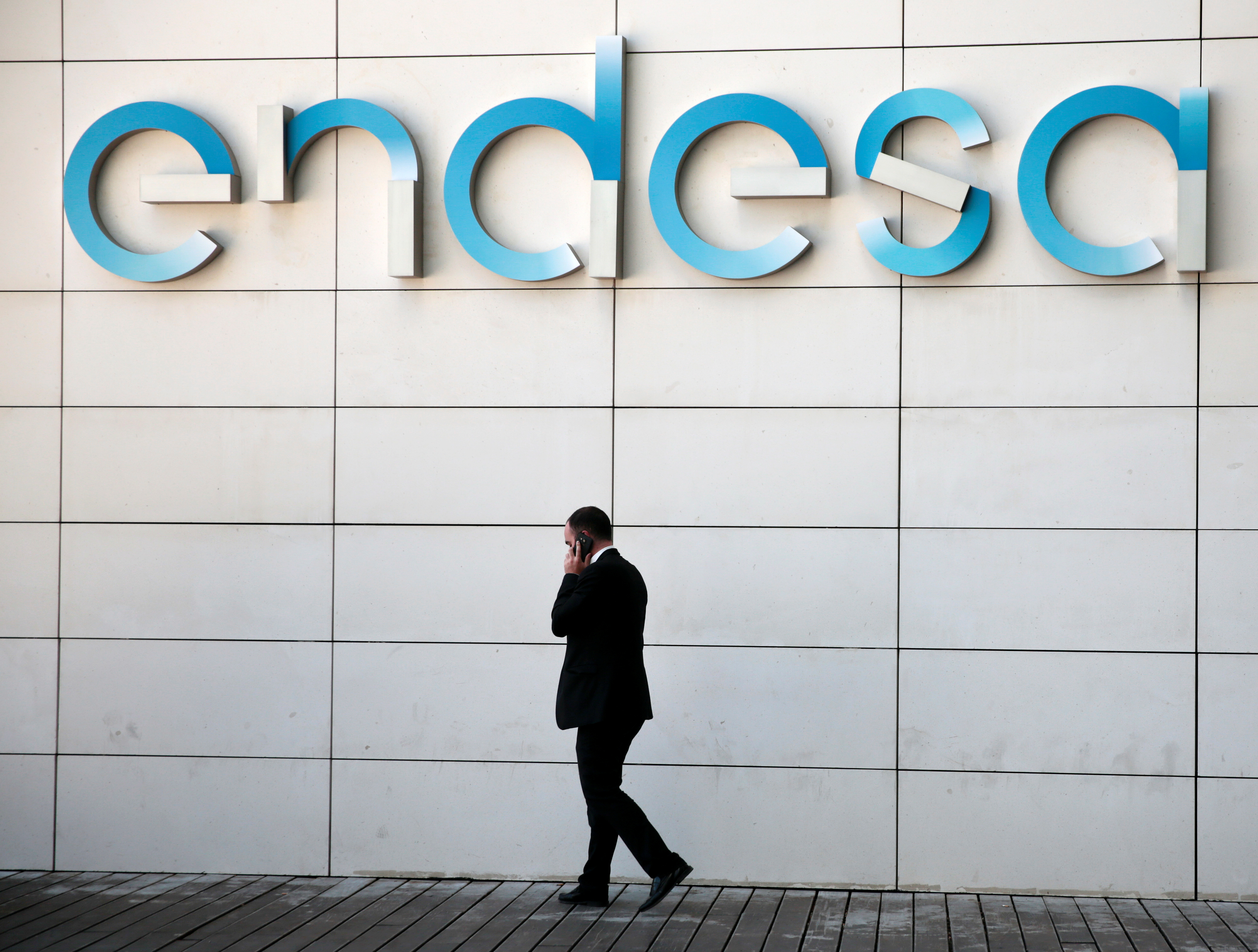 A man walks under the logo of Spanish power company Endesa at their headquarters in Madrid
