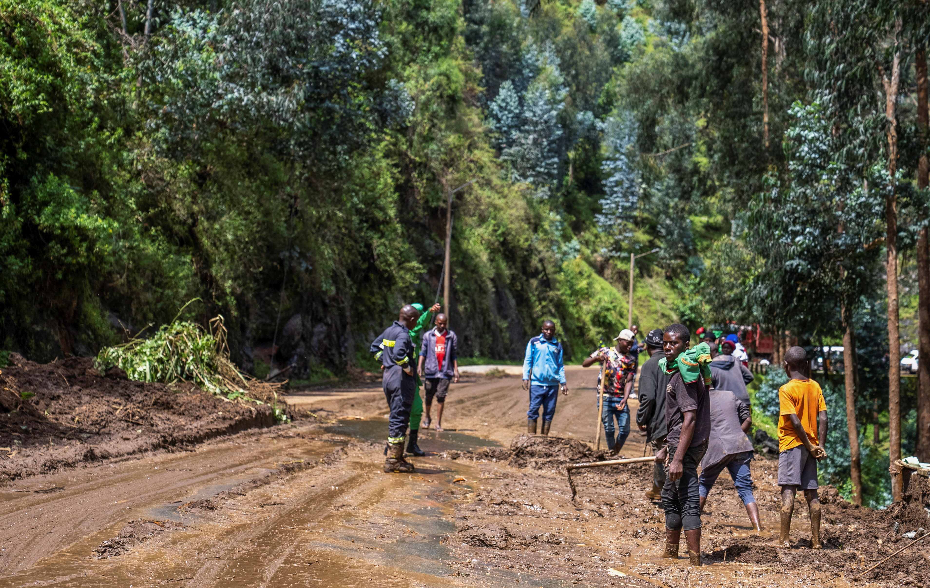 Residents clear mud from the road following rains that triggered flooding and landslides in Rubavu district