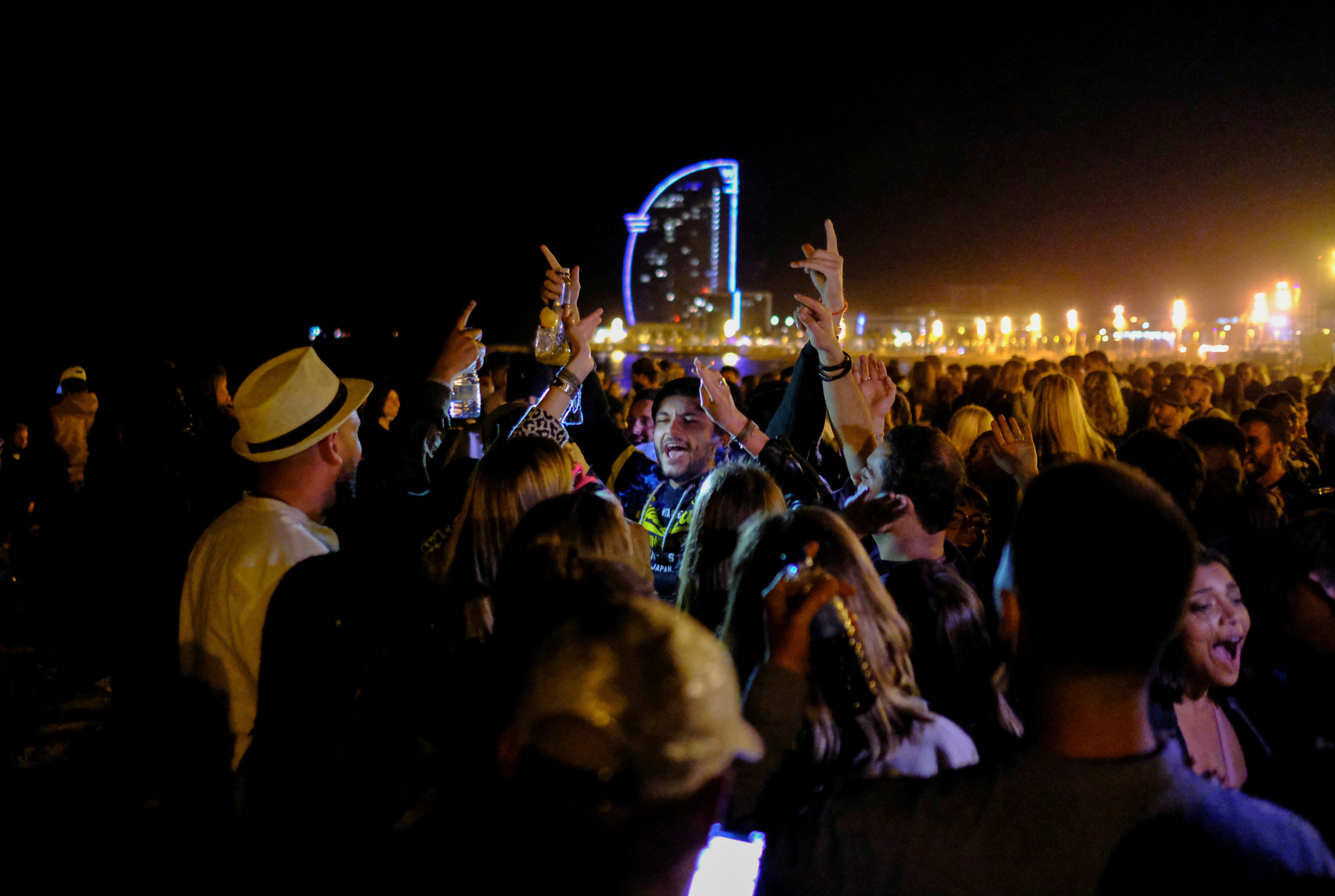 Mensen dansen op het strand van Barceloneta, terwijl de noodtoestand die door de Spaanse regering is afgekondigd om de verspreiding van het coronavirus (COVID-19) te voorkomen, een week geleden werd opgeheven in Barcelona, ​​Spanje, op 16 mei 2021. REUTERS/Nacho Doce