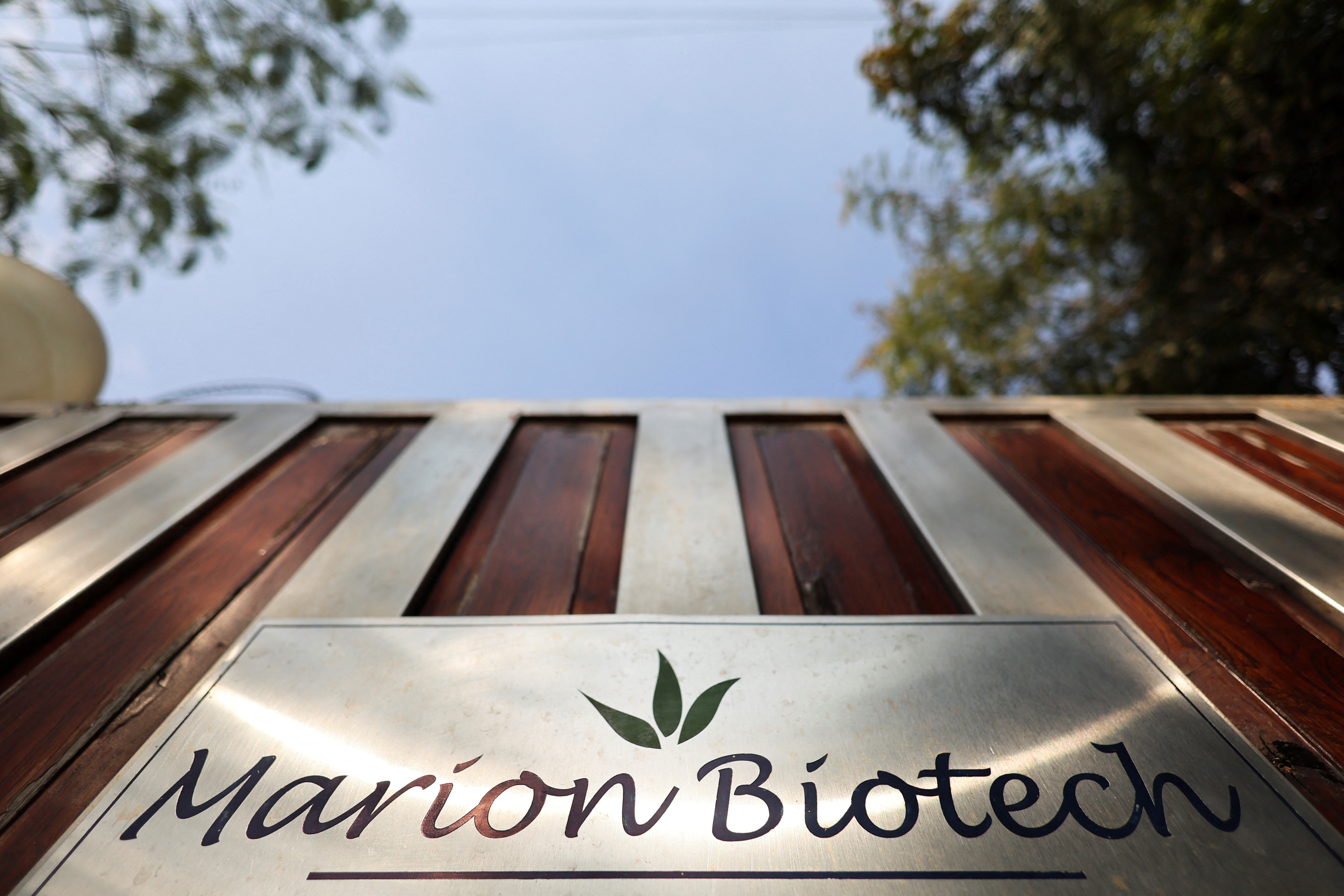 The logo of Marion Biotech, a healthcare and pharmaceutical company, is seen on the gate outside its office in Noida