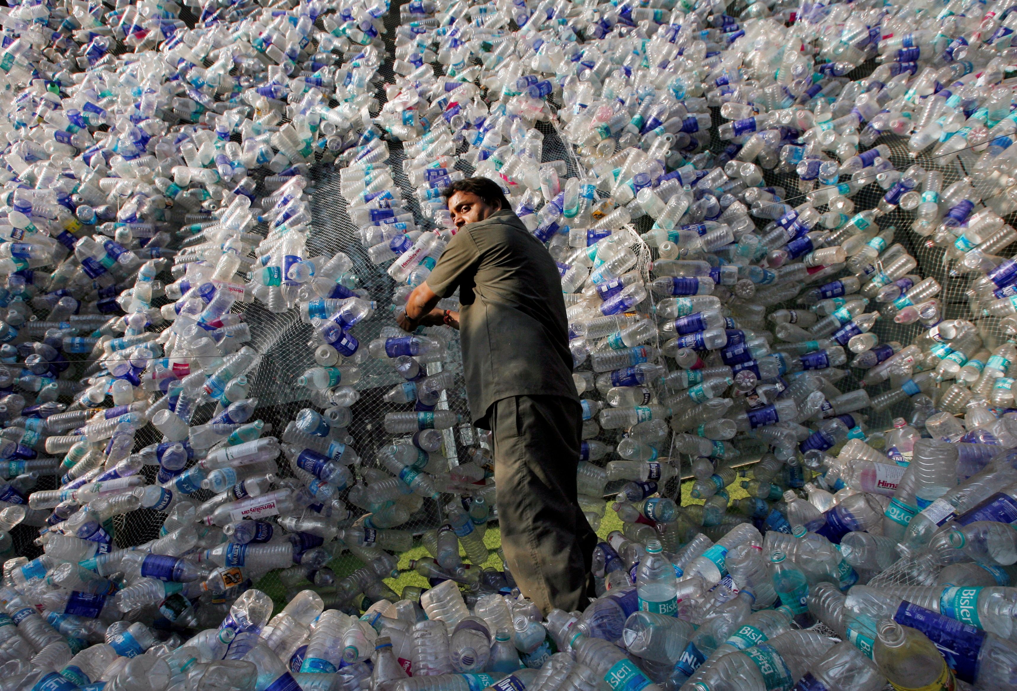 An employee of Mumbai Educational Trust (MET), which runs educational institutes, adjusts plastic bottles in an installation made of approximately 40,000 plastic bottles to protest the use of plastic, in Mumbai November 19, 2009. REUTERS/Arko Datta