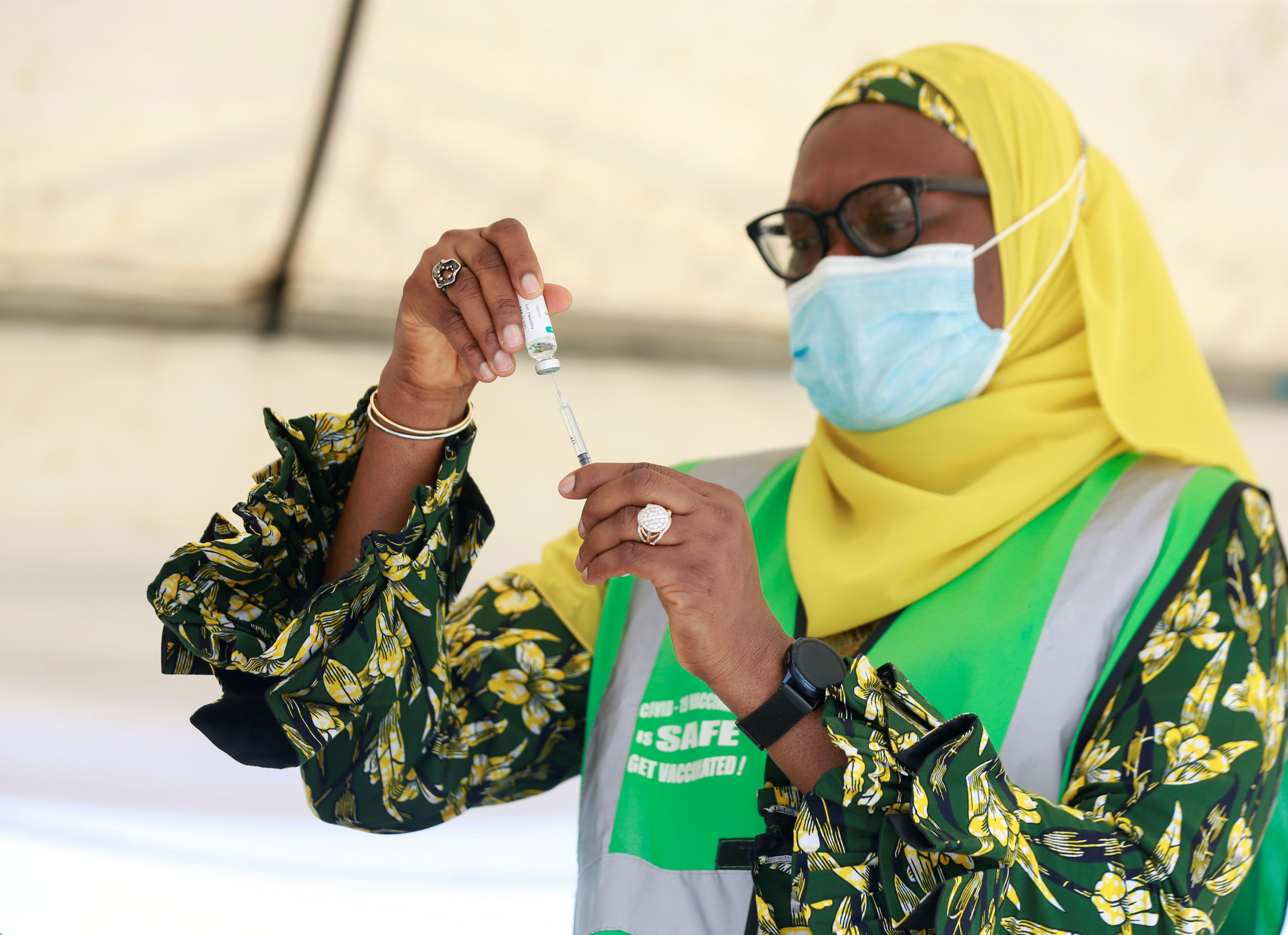 A health worker takes a dose of the COVID-19 vaccine from a vial during the roll out of mass vaccination in Abuja