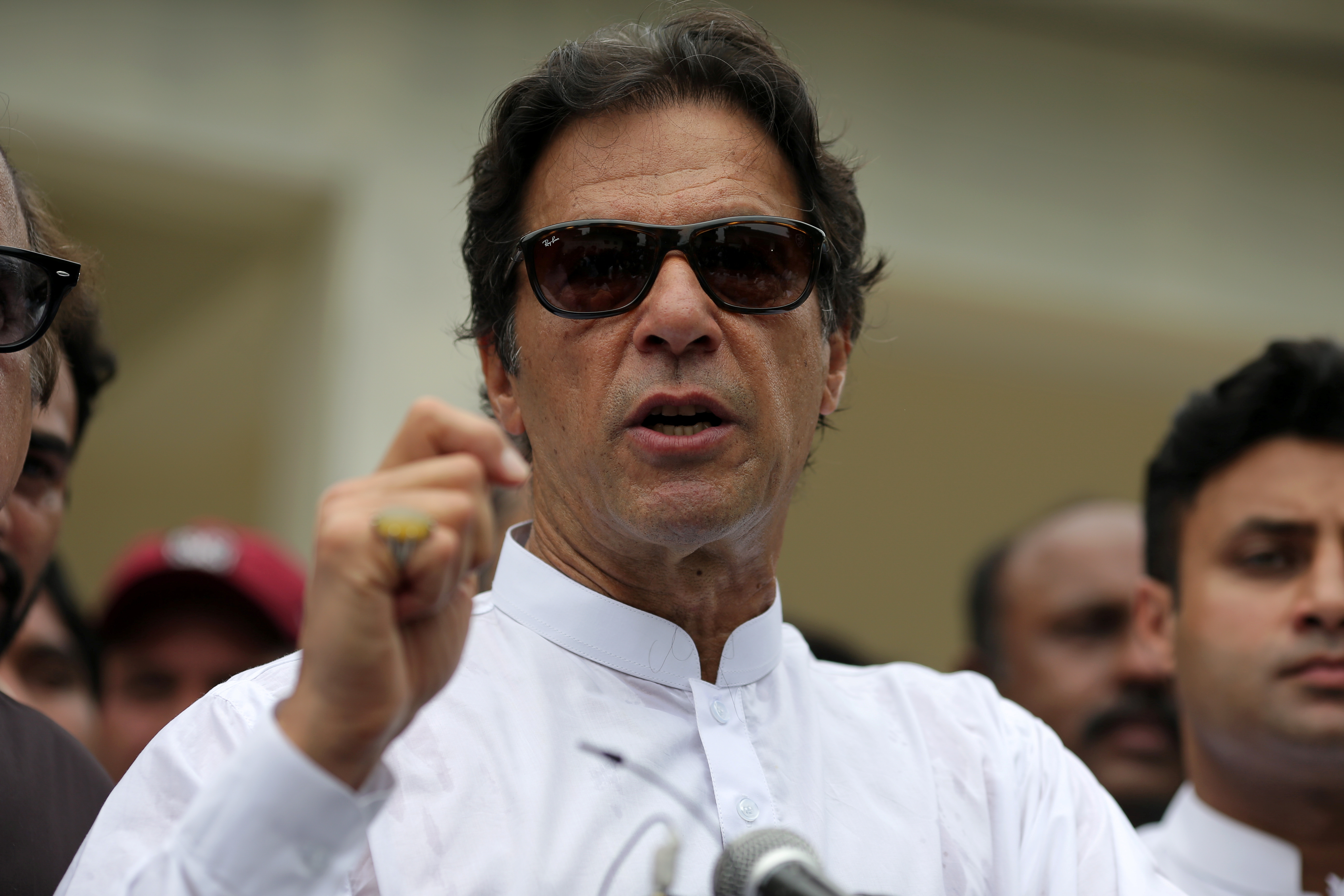 Cricket star-turned-politician Imran Khan, chairman of Pakistan Tehreek-e-Insaf (PTI), speaks to members of media after casting his vote at a polling station during the general election in Islamabad