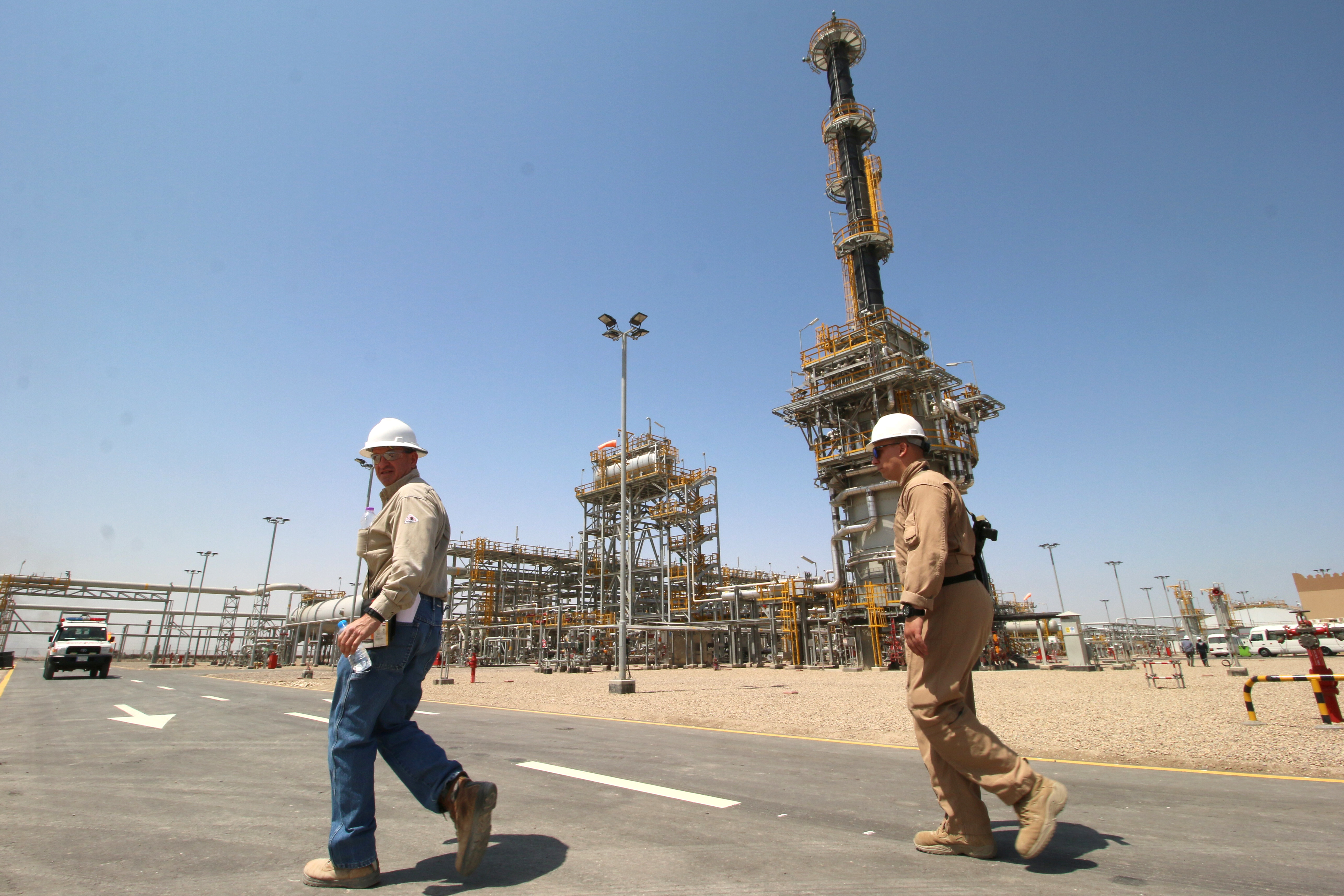 A member of security foreign personnel walks with an Exxon's foreign staff of the West Qurna-1 oilfield, which is operated by ExxonMobil, during the opening ceremony near Basra, Iraq June 17, 2019.  REUTERS/Essam Al-Sudani