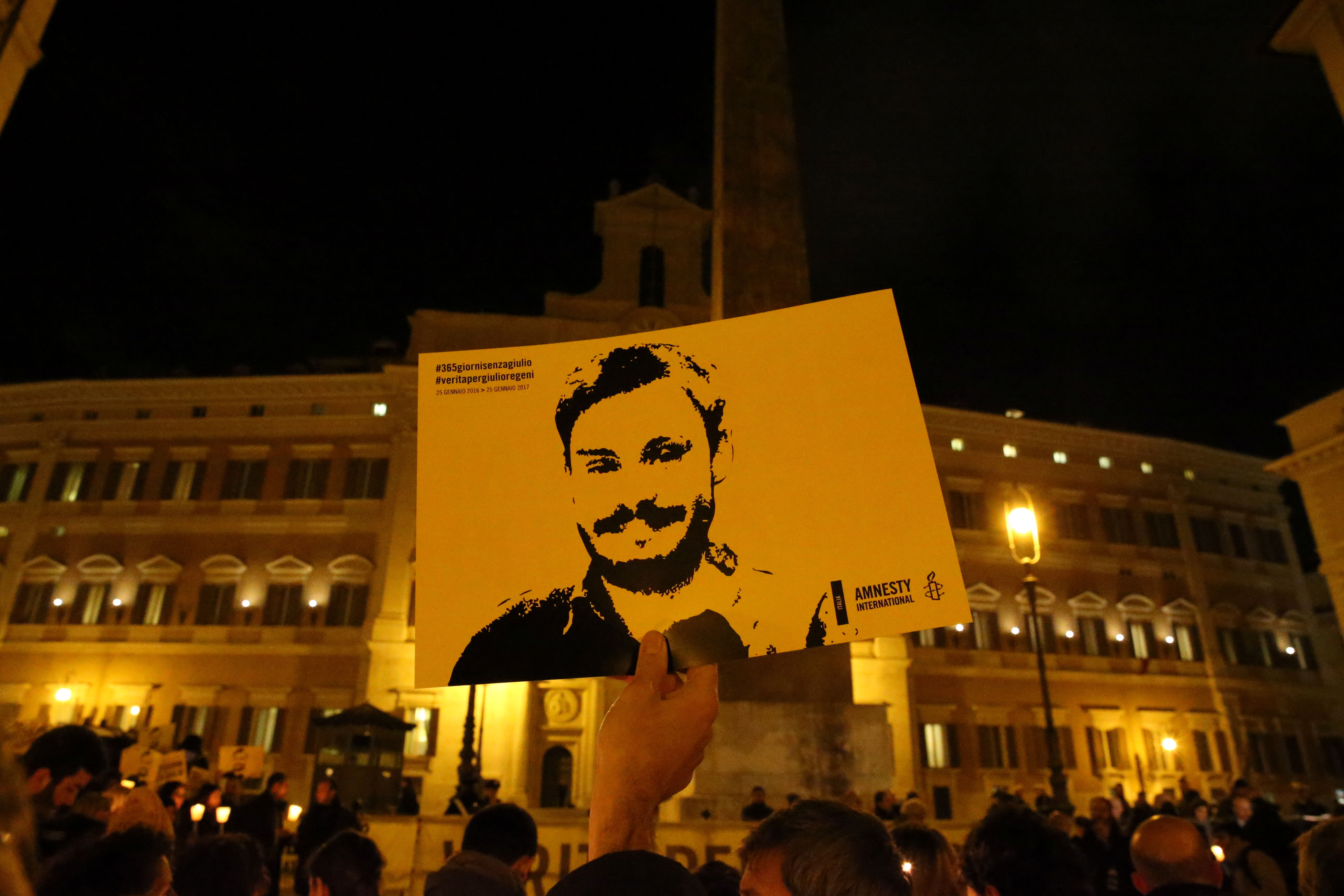 A man holds a placard during a vigil to commemorate Giulio Regeni, who was found murdered in Cairo a year ago, in downtown Rome
