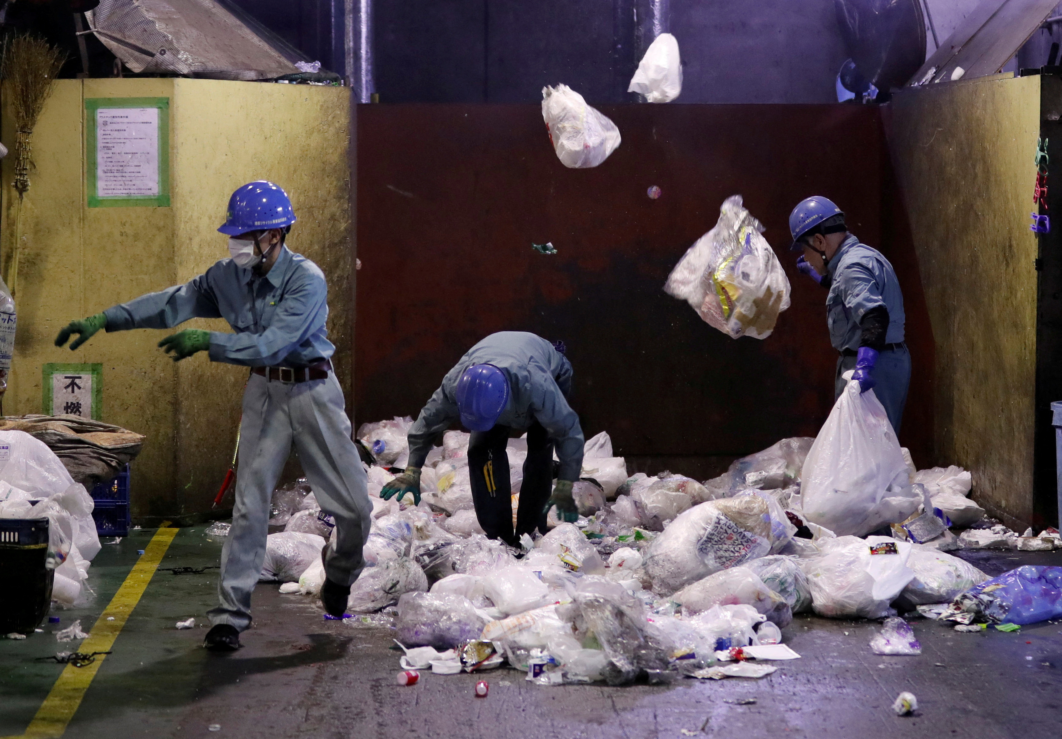 Workers sort out plastic waste for recycling at Minato Resource Recycle Center in Tokyo