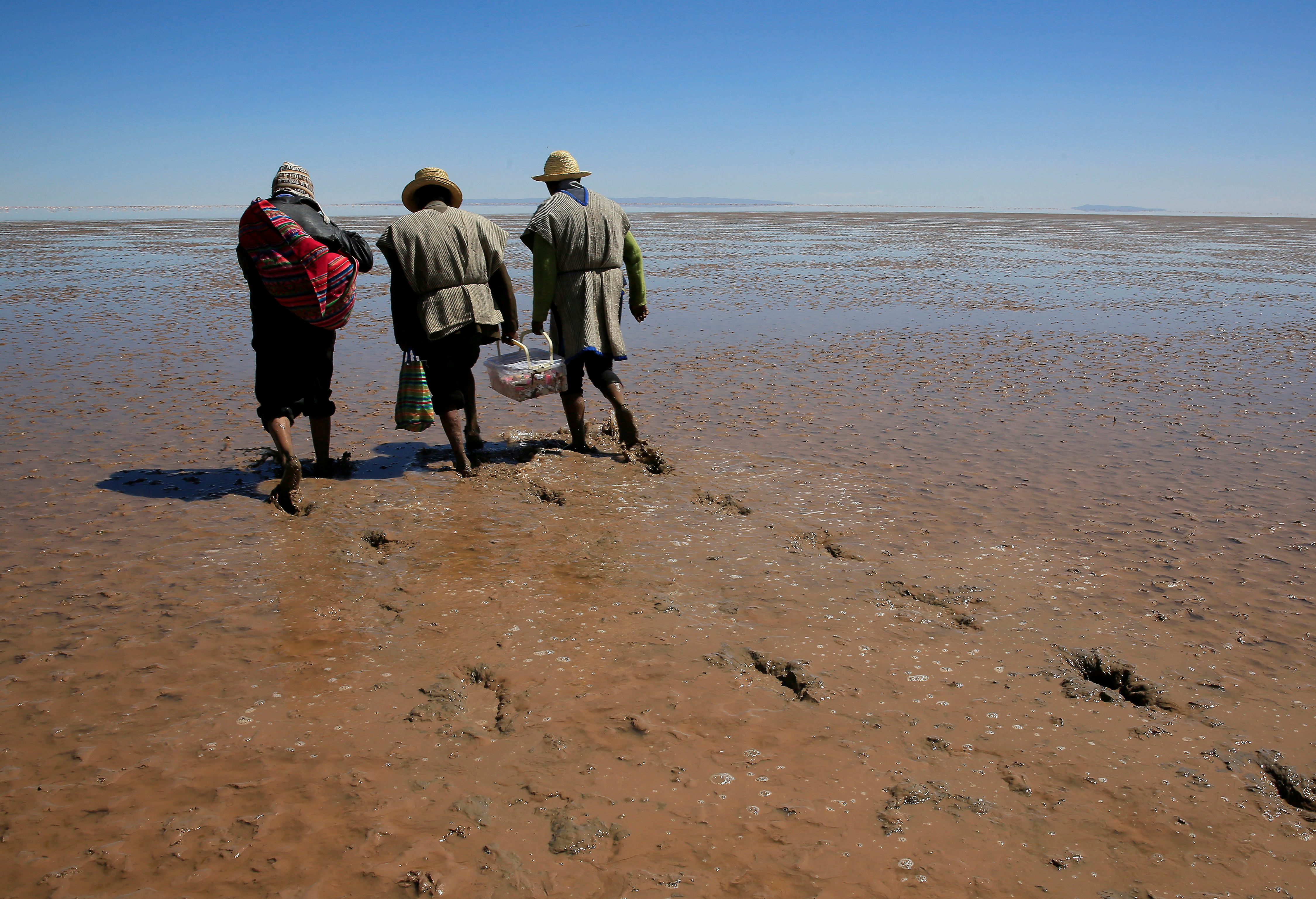 Hombres Urus Muratos caminan sobre el lago seco Poopo afectado por el cambio climático para hacer una ofrenda a Kota Mama (Madre Agua), en el Departamento de Oruro