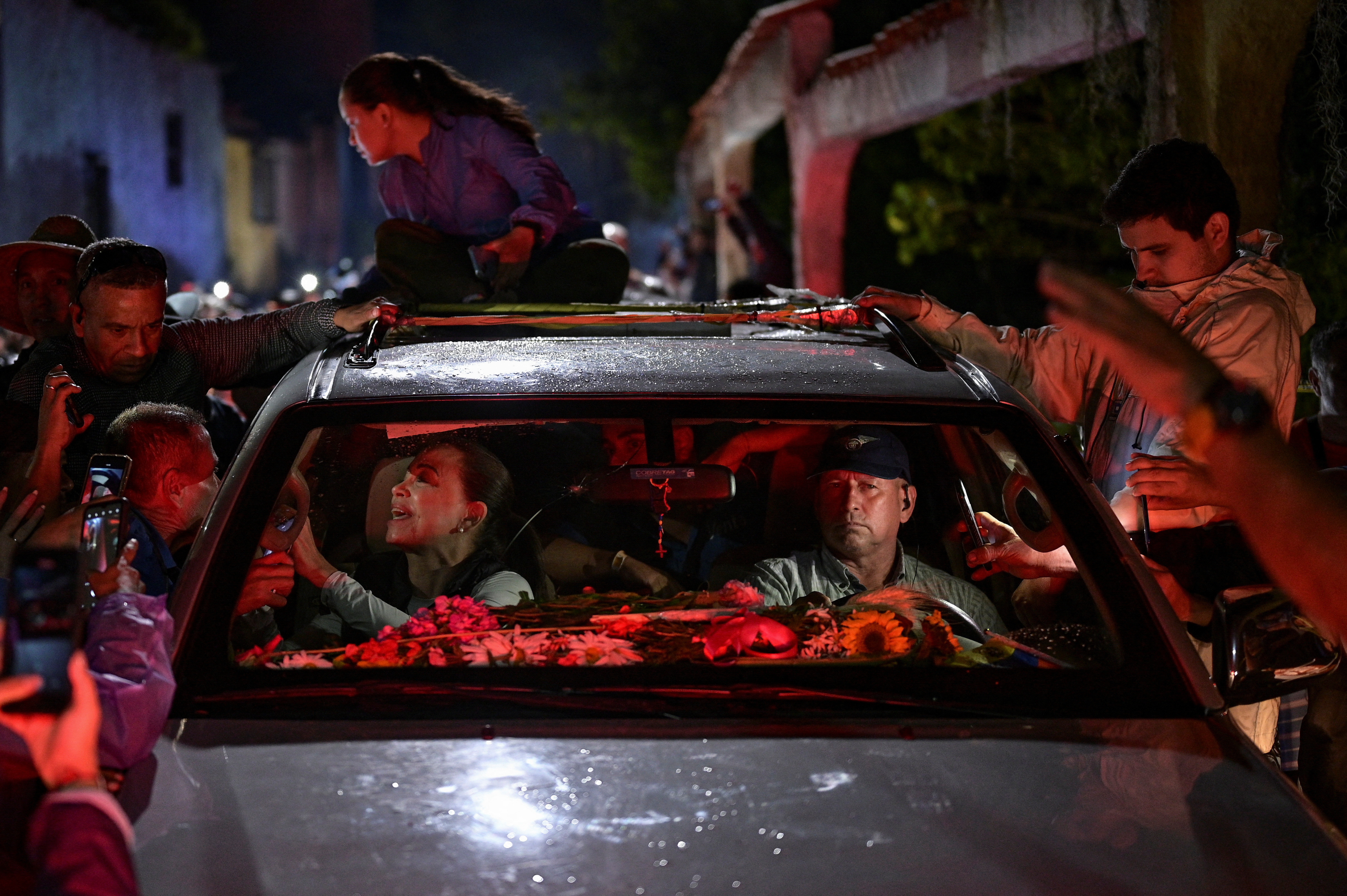Milciades Avila, security chief of opposition leader Maria Corina Machado, drives her car during a rally, in Merida state