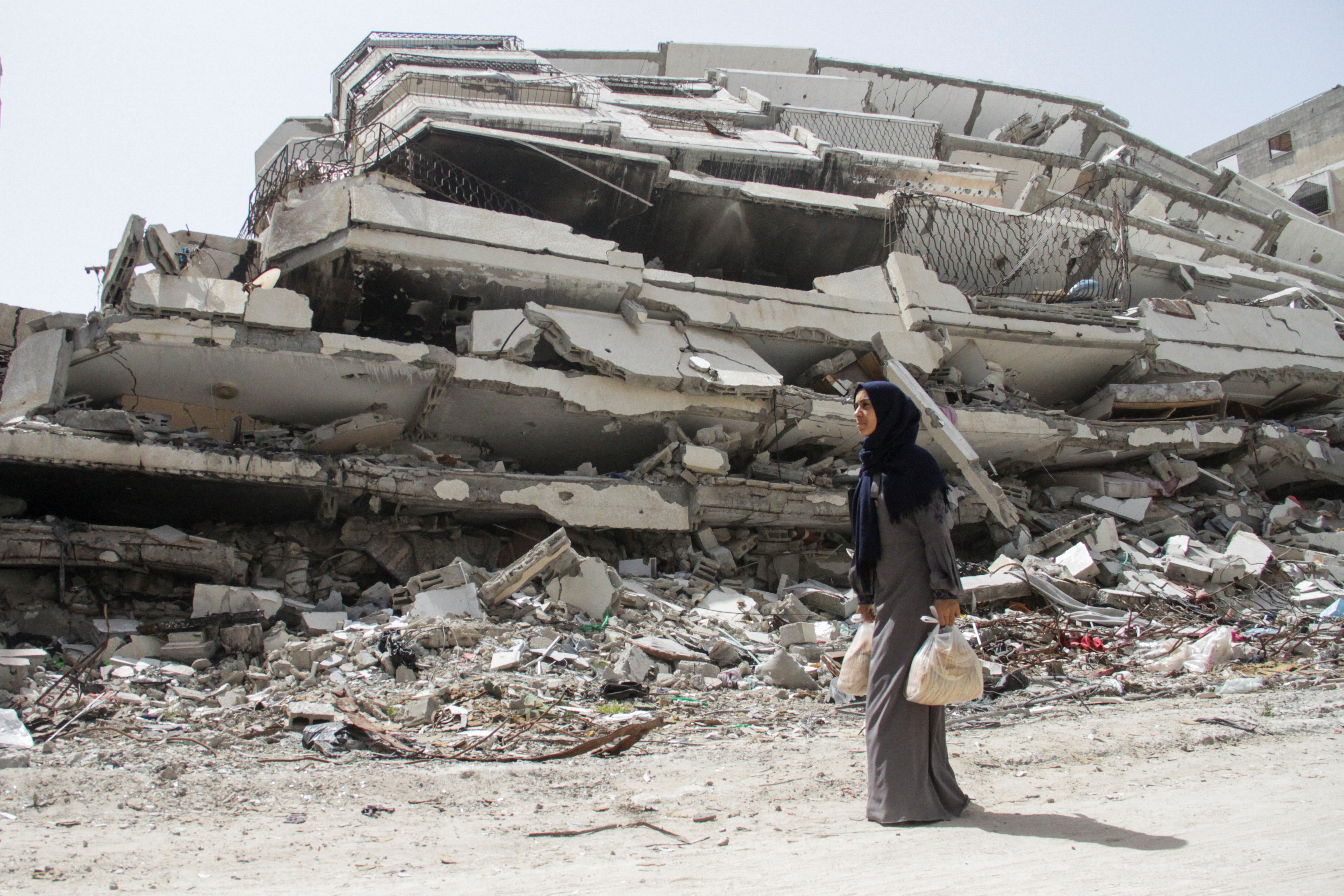 Palestinian woman Asmaa Al-Belbasi making her way back to her shelter after buying bread from a bakery, in Gaza City