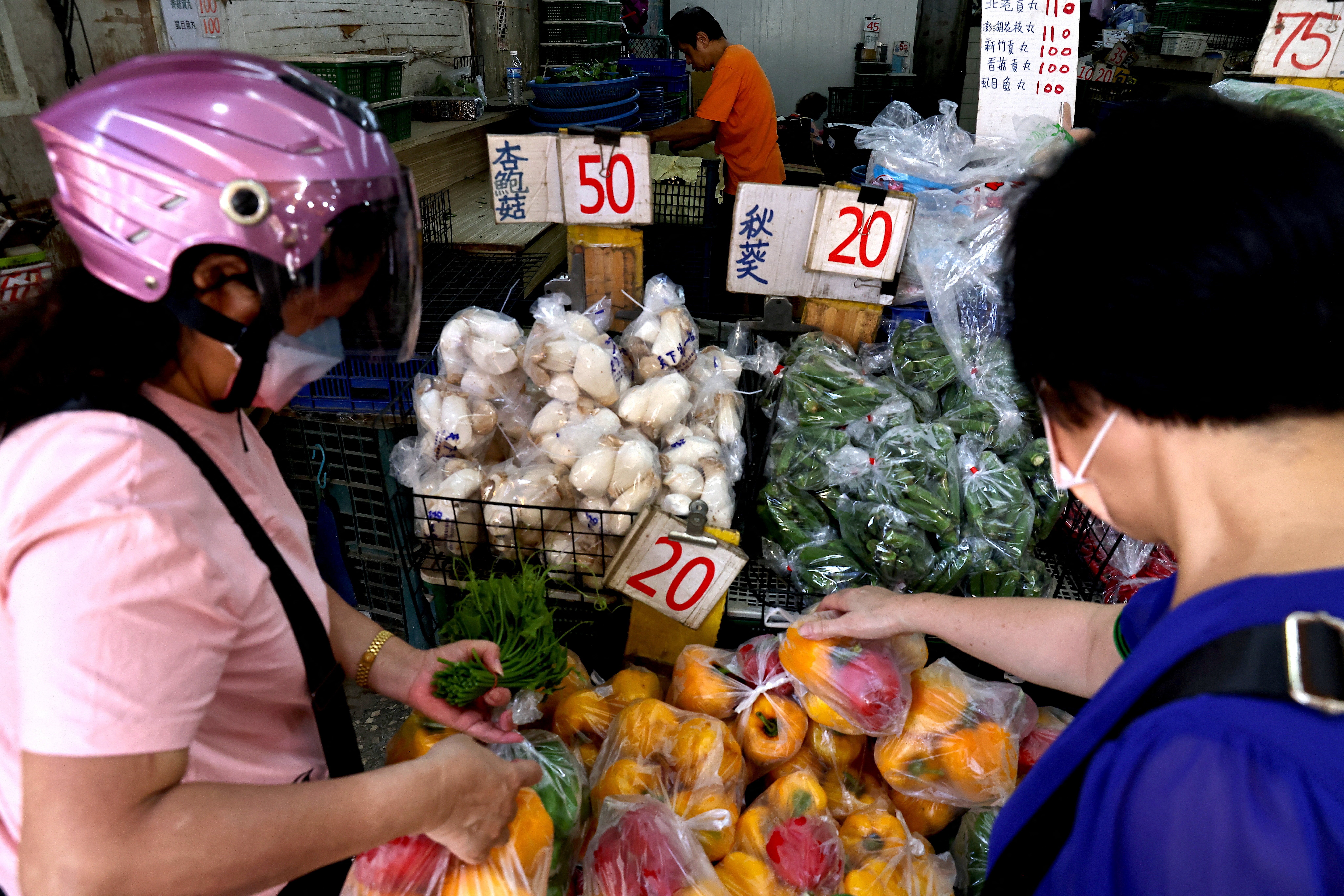People buy vegetables at a shop in Taipei