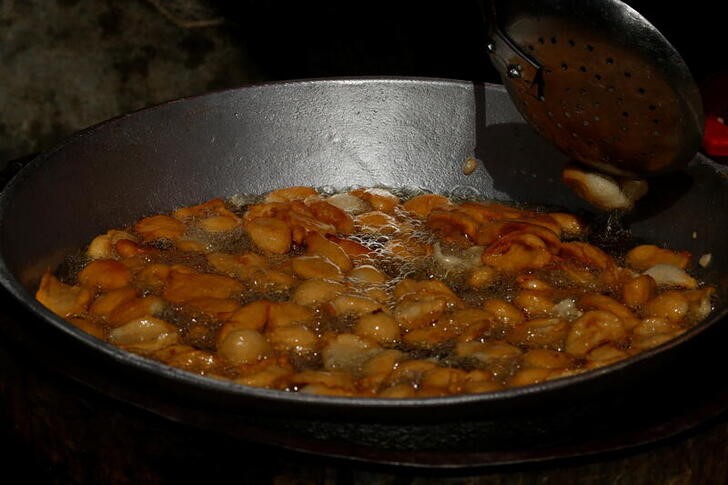 Djeneba Belem fries bean cakes in cooking oil made from palm oil, in Abidjan