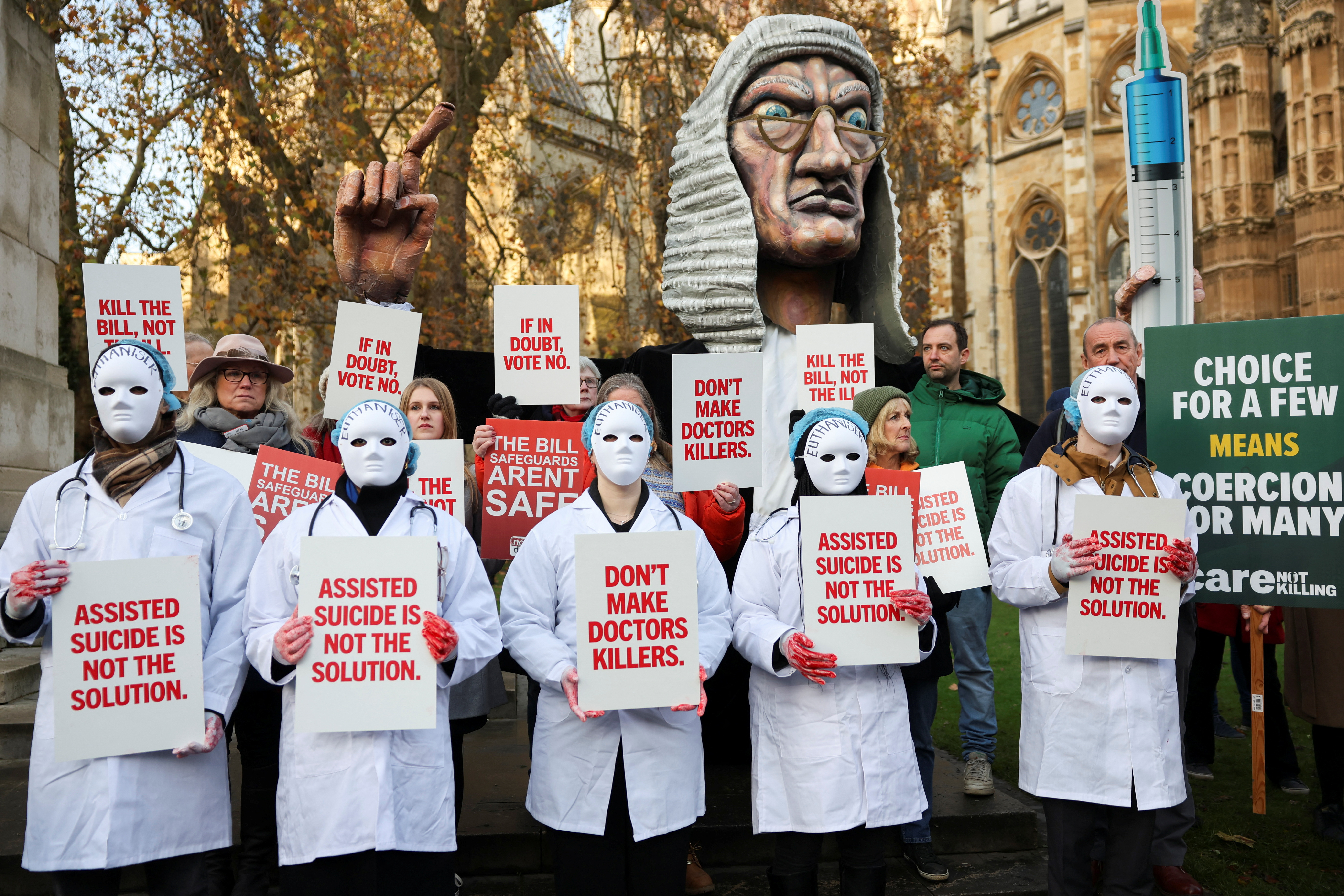 Protestors gather as British lawmakers debate the assisted dying law, in London