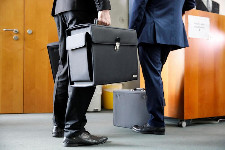 Business trip. Businessman in suit with hand luggage and world map