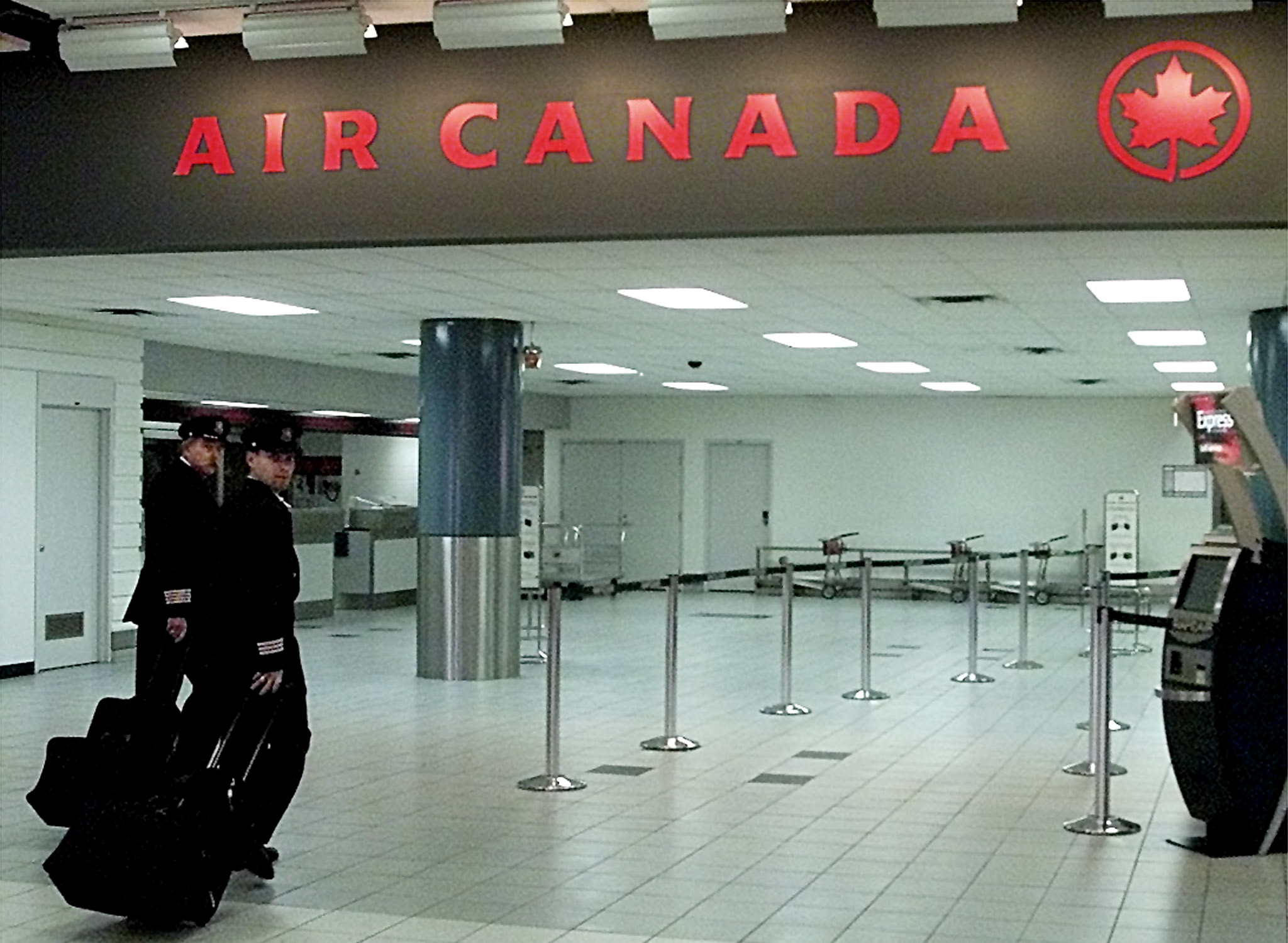 Air Canada pilots walk towards their gate at Toronto's Pearson International Airport