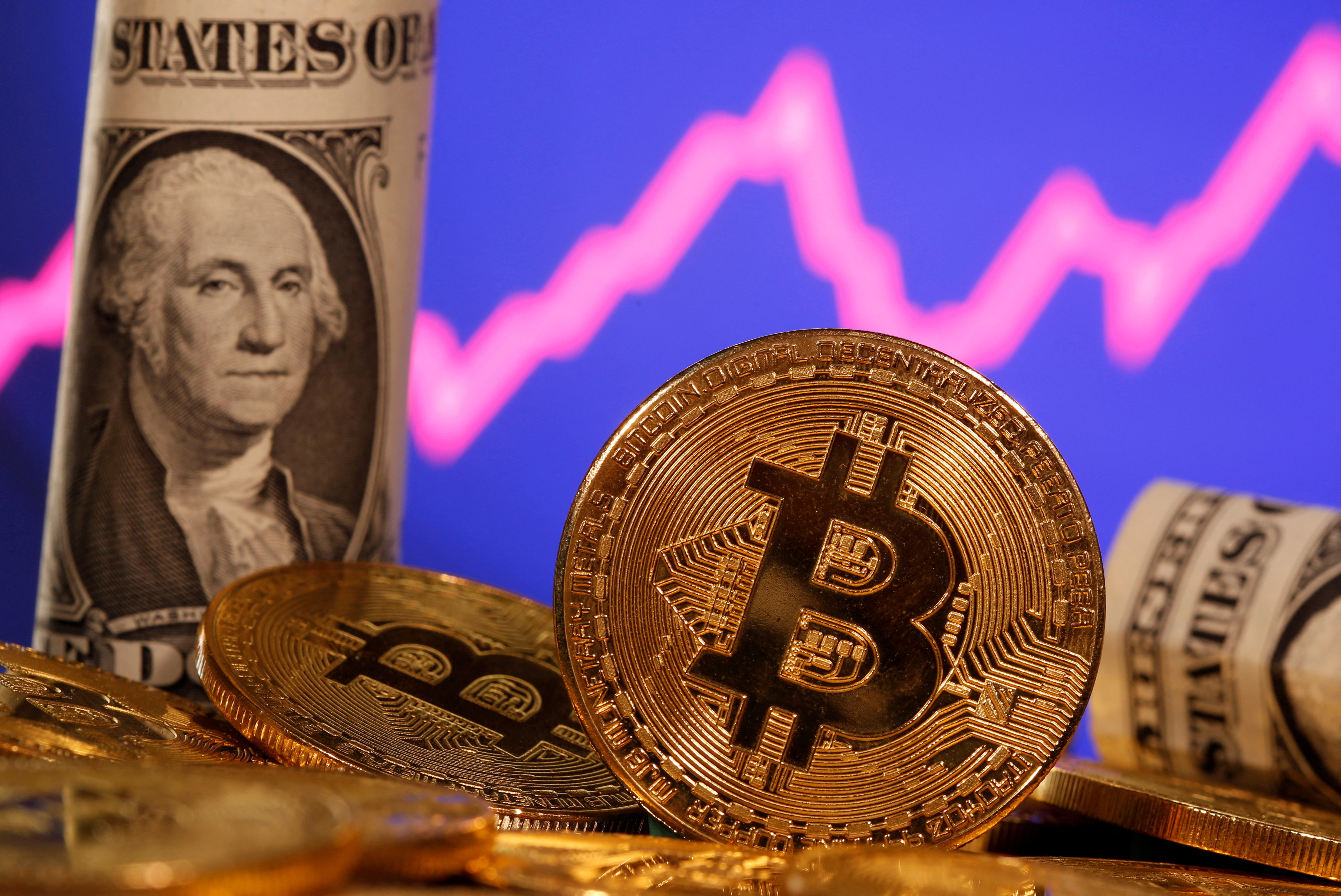 A representation of virtual currency bitcoin and a U.S. one dollar banknote are seen in front of a stock graph in this illustration