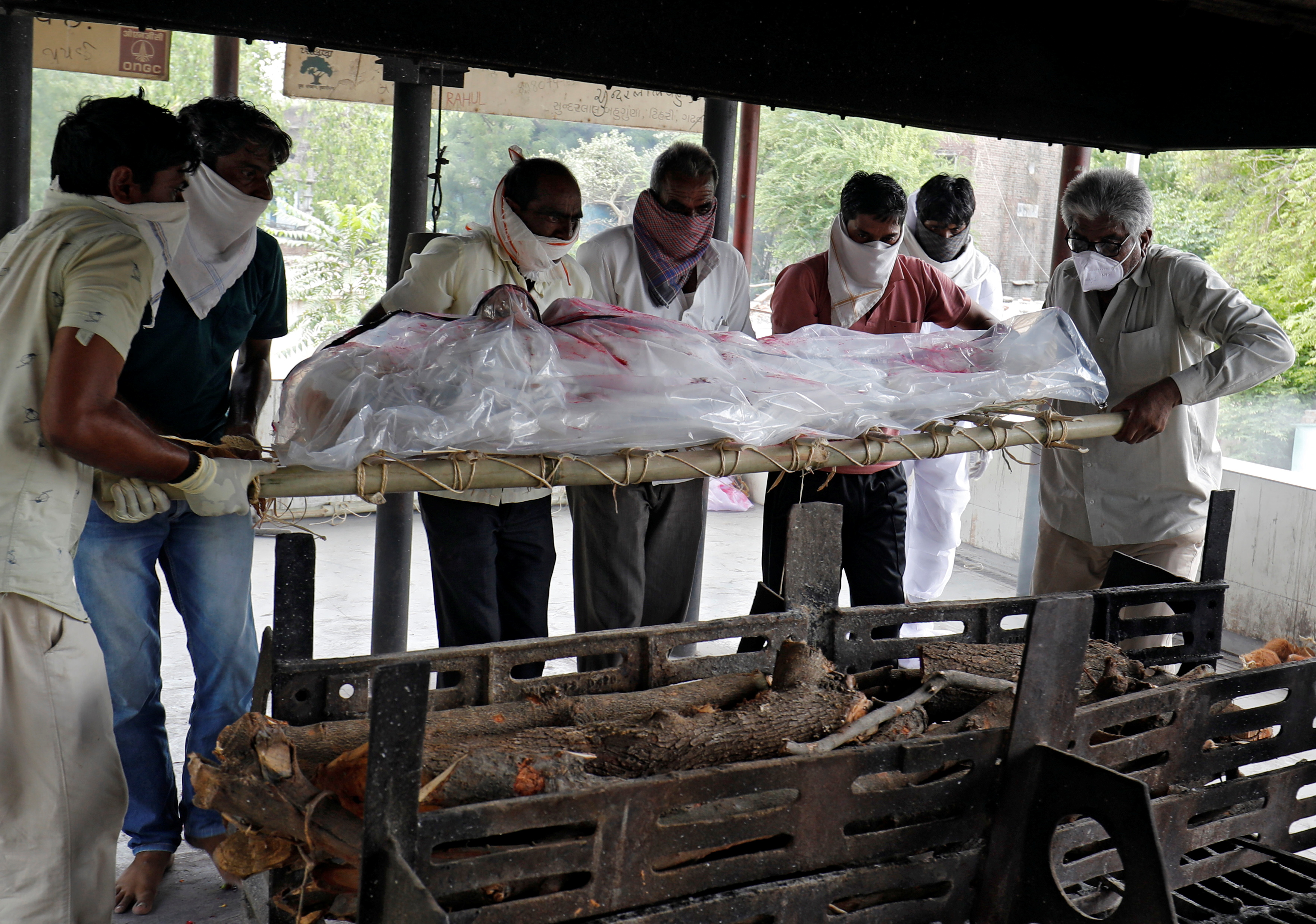 People prepare to cremate their relative, who died from the coronavirus disease (COVID-19) at a crematorium in Ahmedabad
