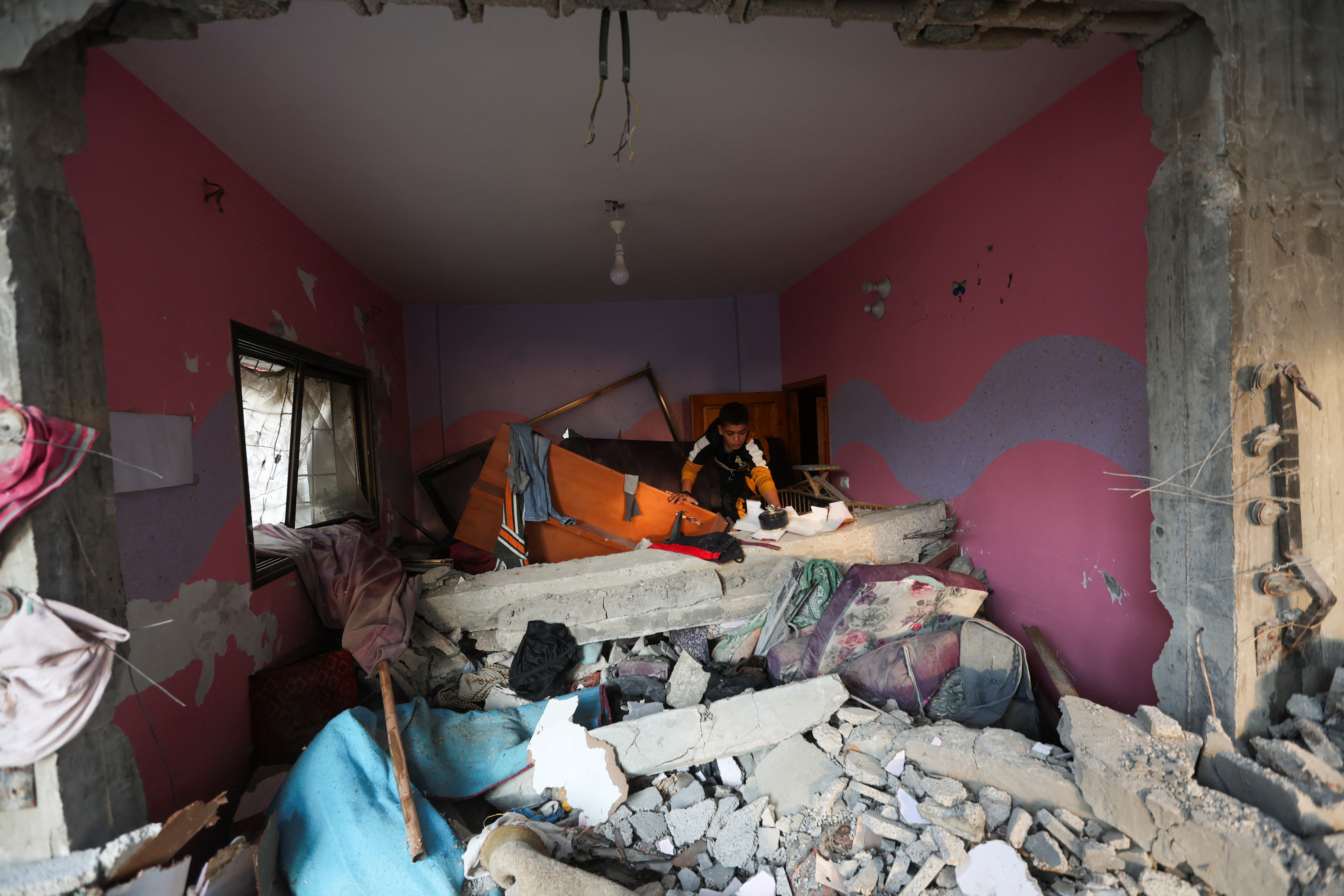 Palestinians inspect a house damaged in an Israeli strike in Rafah