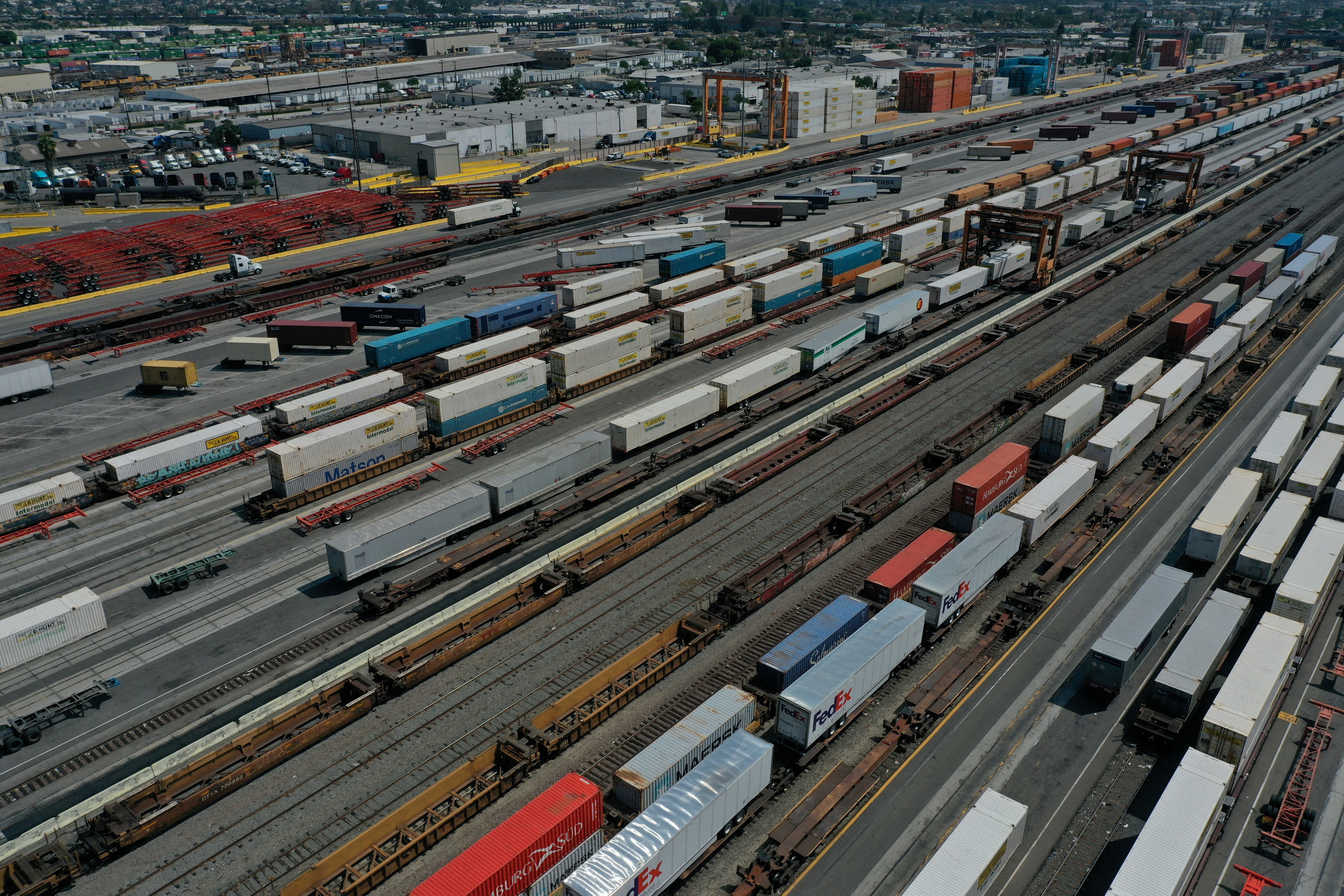 An aerial view of shipping containers and freight railway trains at the BNSF Los Angeles Intermodal Facility rail yard in Los Angele
