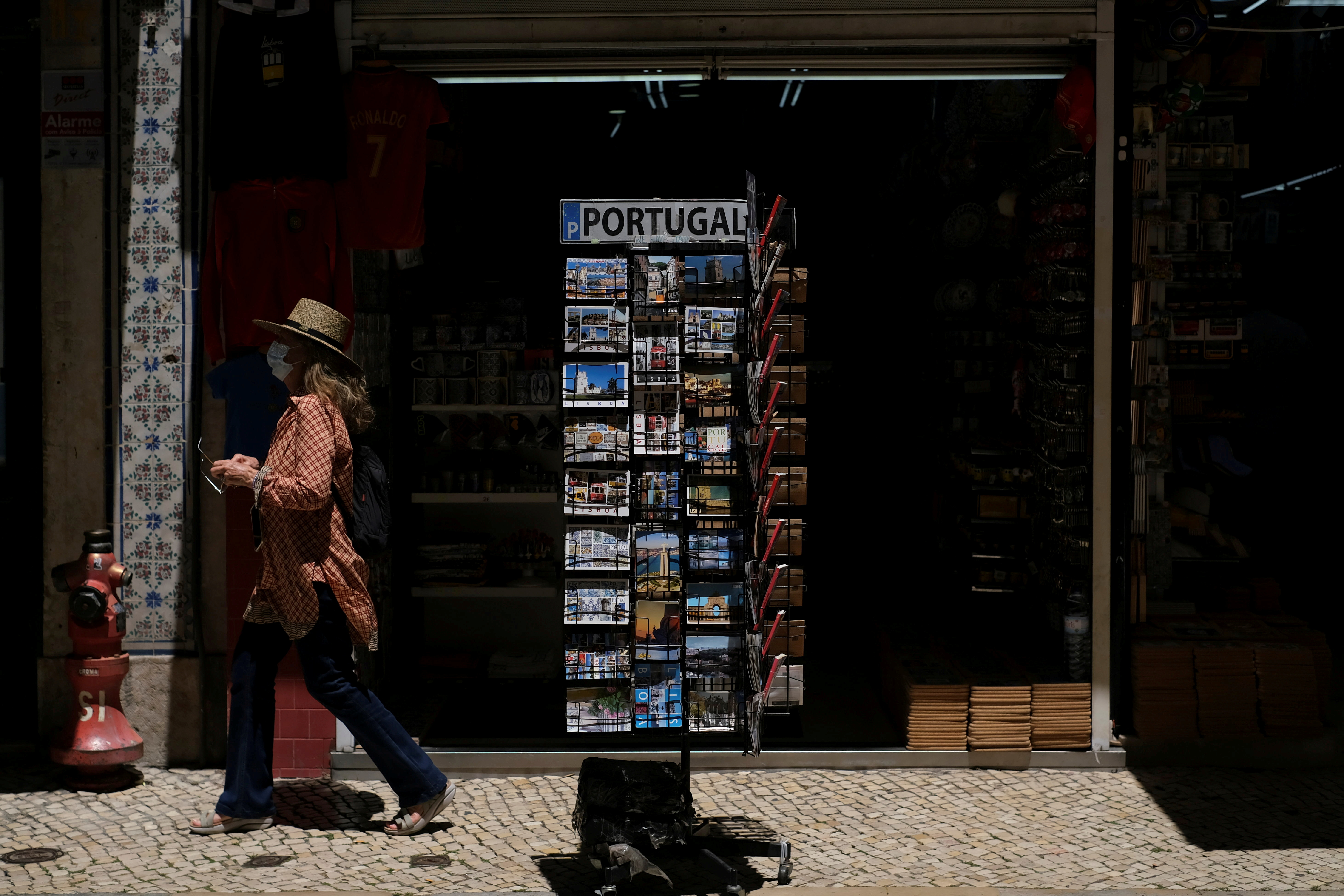 A woman wearing a protective mask walks in Lisbon downtown amid the coronavirus disease (COVID-19) pandemic, in Lisbon