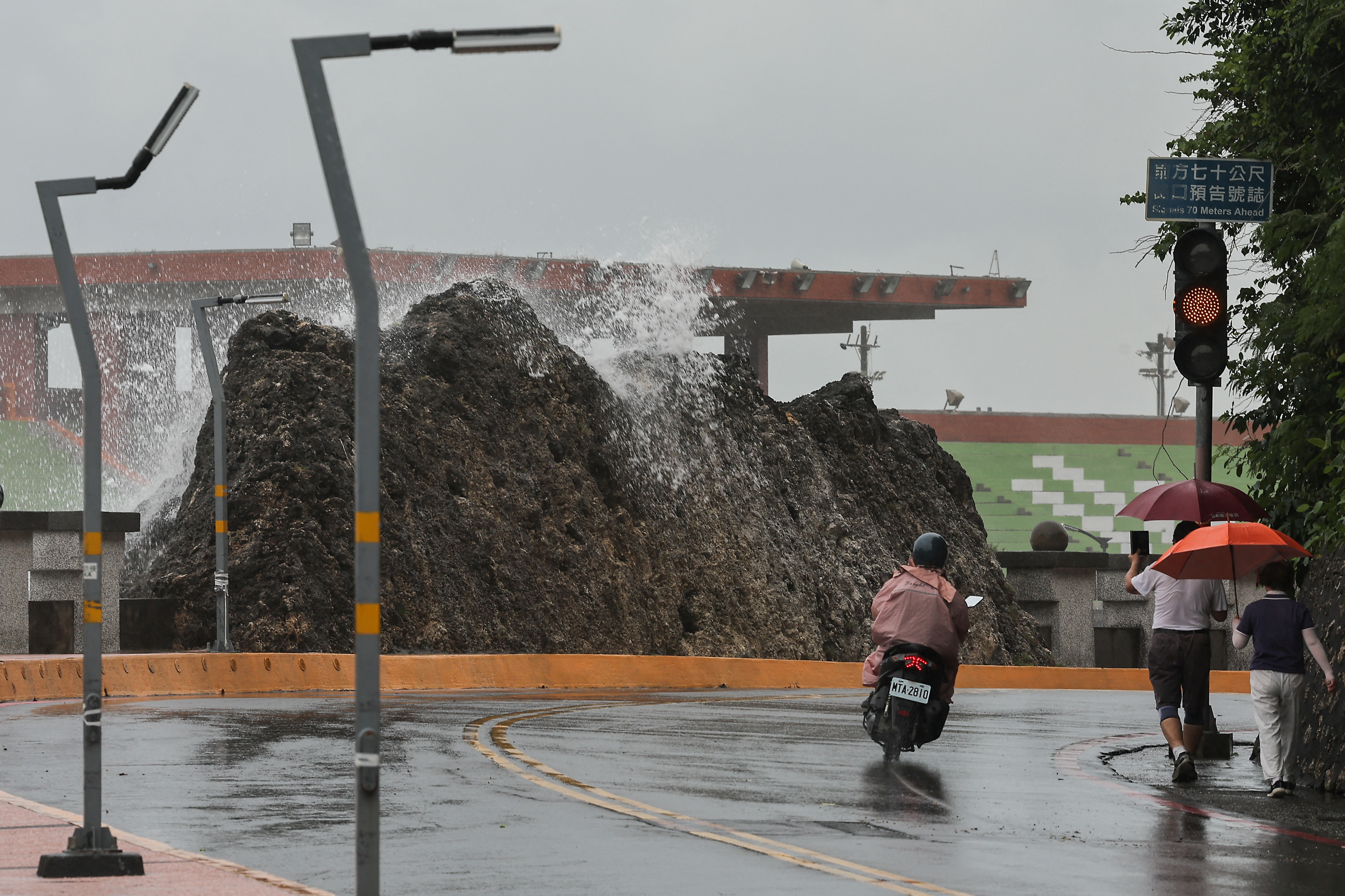 A person takes photos of the wave as Typhoon Krathon approaches Kaohsiung