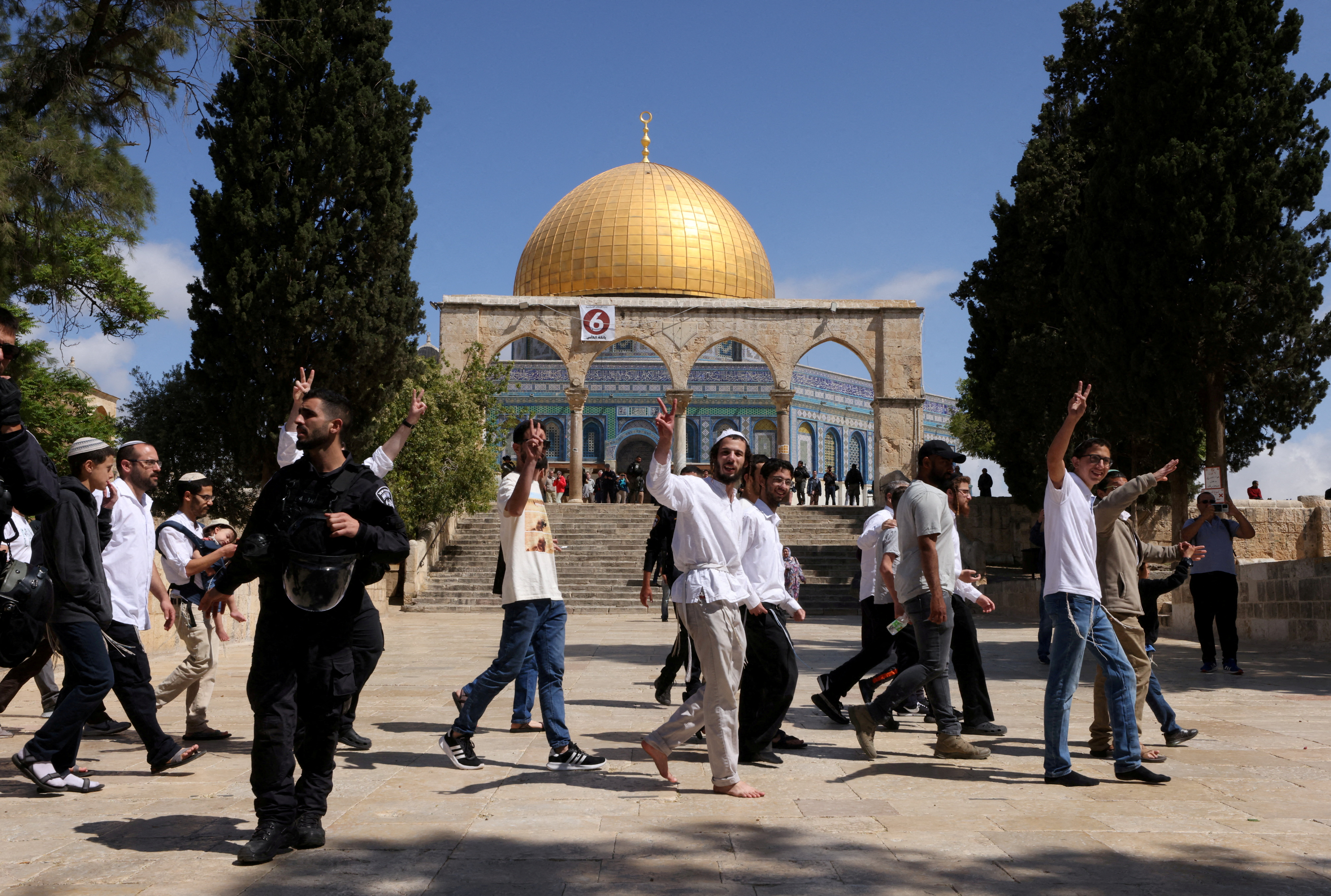 FILE PHOTO: Jewish visitors gesture as Israeli security forces secure the area at the compound that houses Al-Aqsa Mosque in Jerusalem