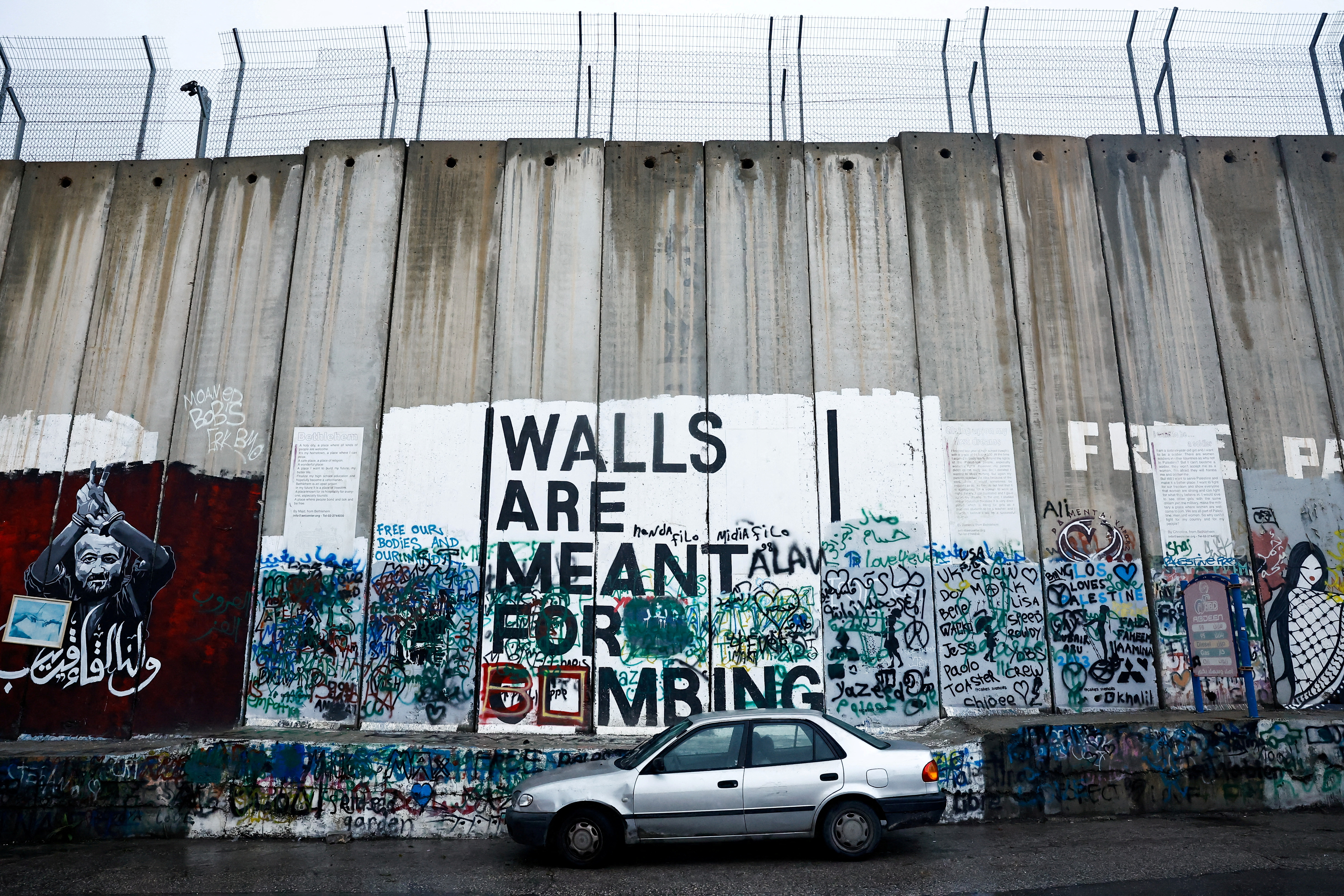 A car is parked next to the Israeli wall in Bethlehem