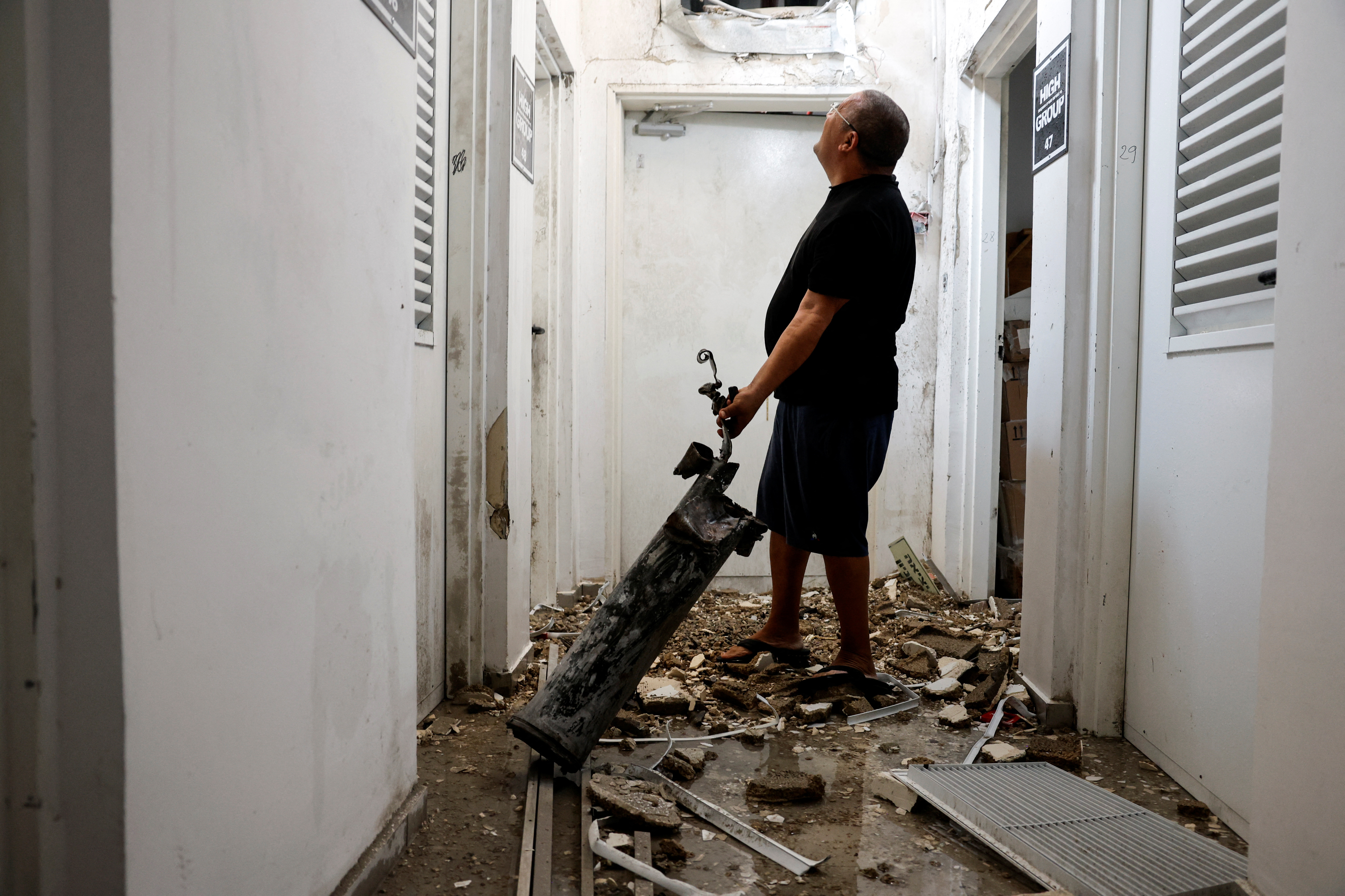 A man holds the remains of a rocket that was launched from the Gaza Strip and landed in Ashkelon