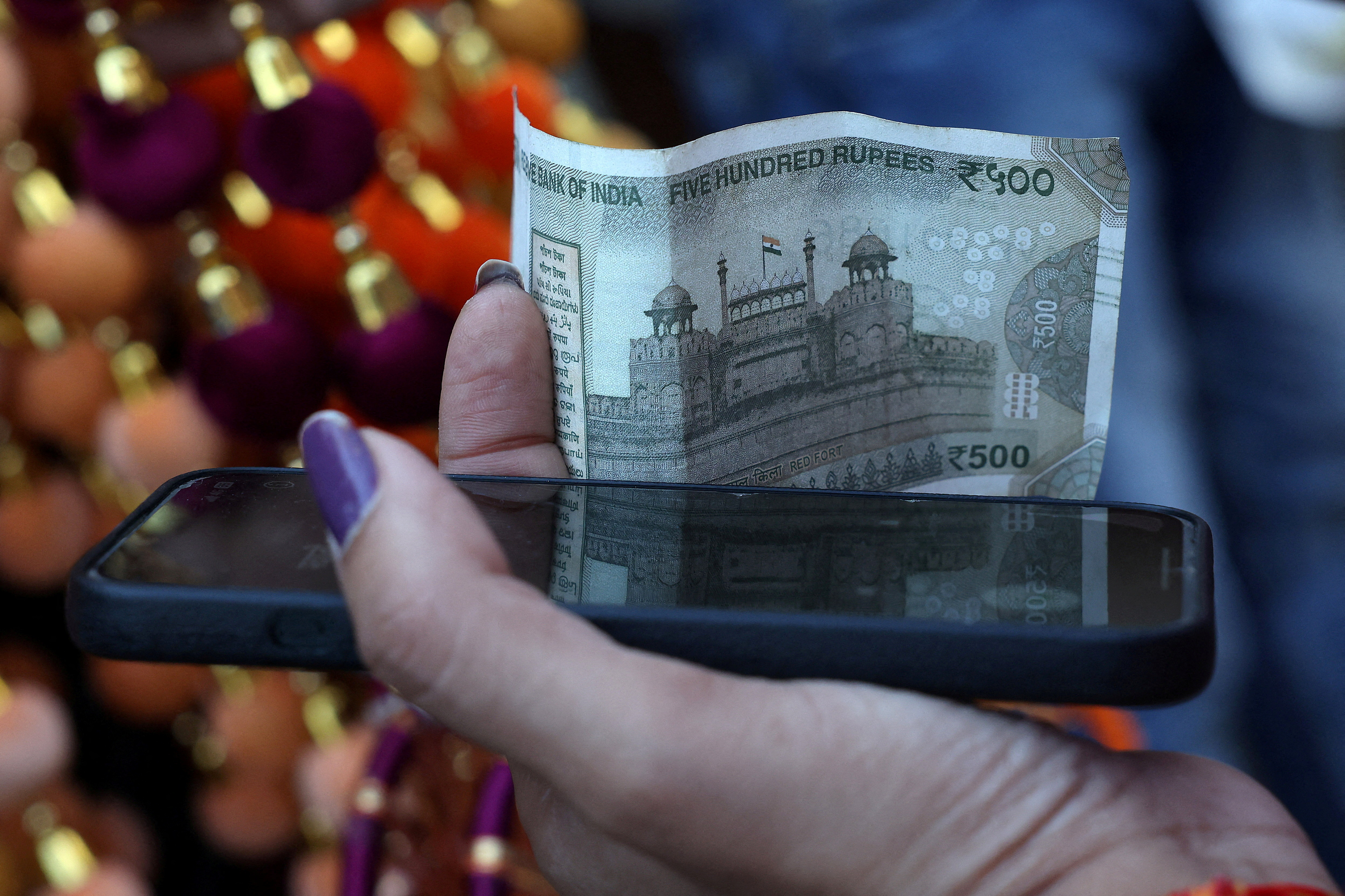 Indian rupee slips to record low, central bank intervention curbs fall |  Reuters